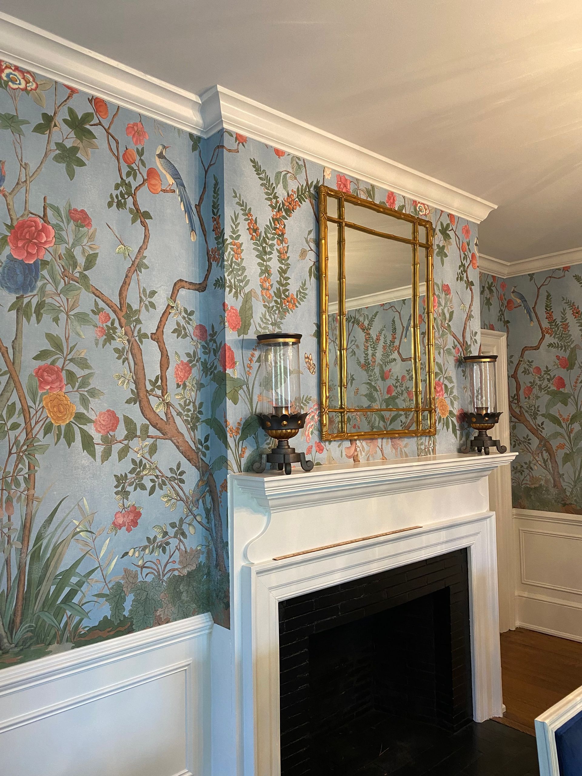 A living room with a fireplace and a mirror on the mantle.