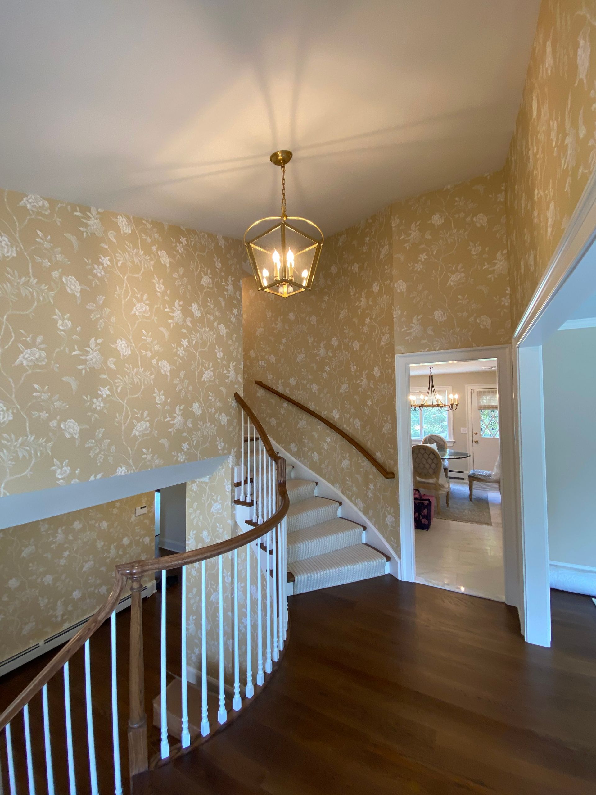 A staircase in a house with a chandelier hanging from the ceiling.