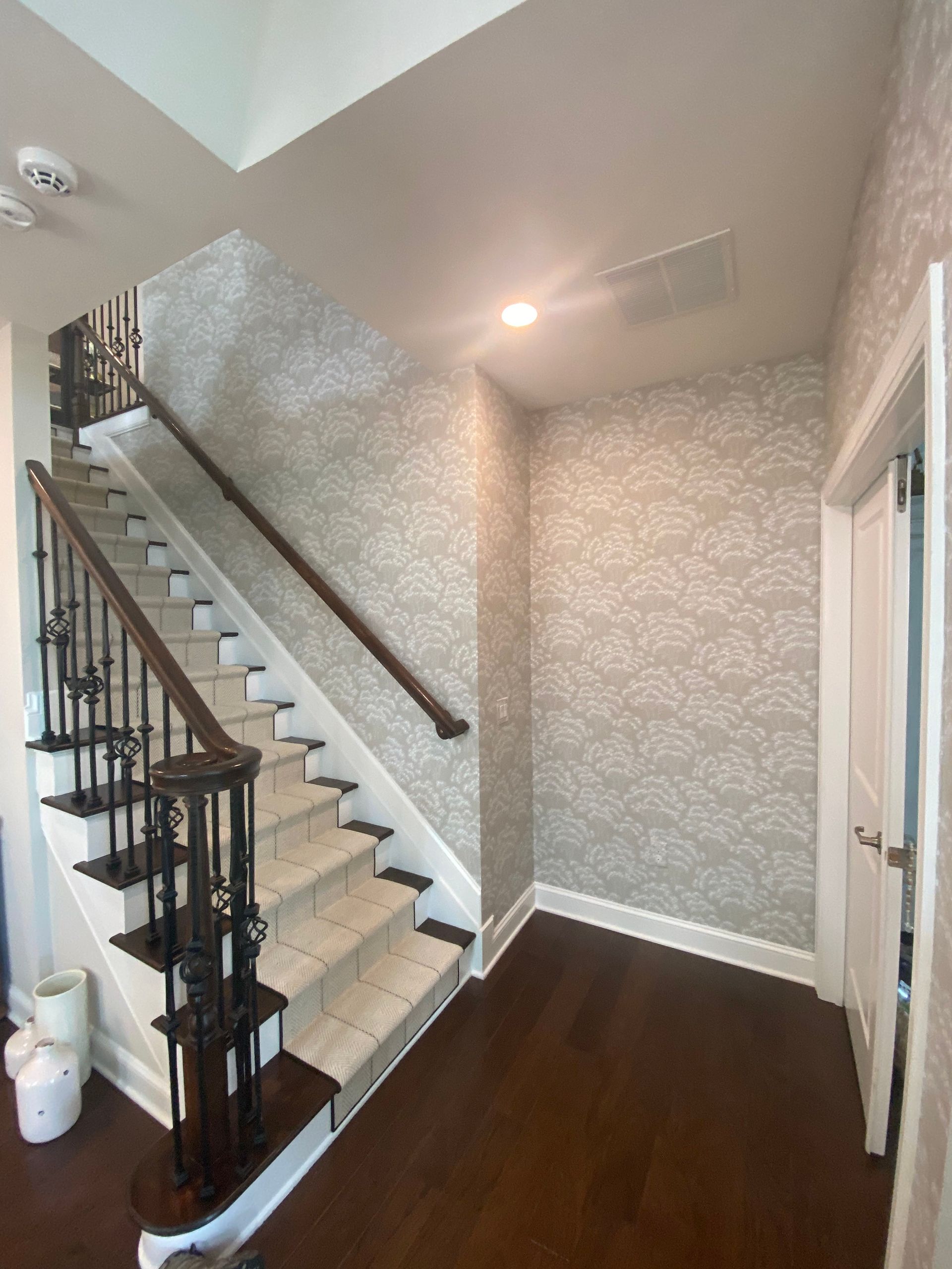 A hallway with stairs leading up to the second floor of a house.