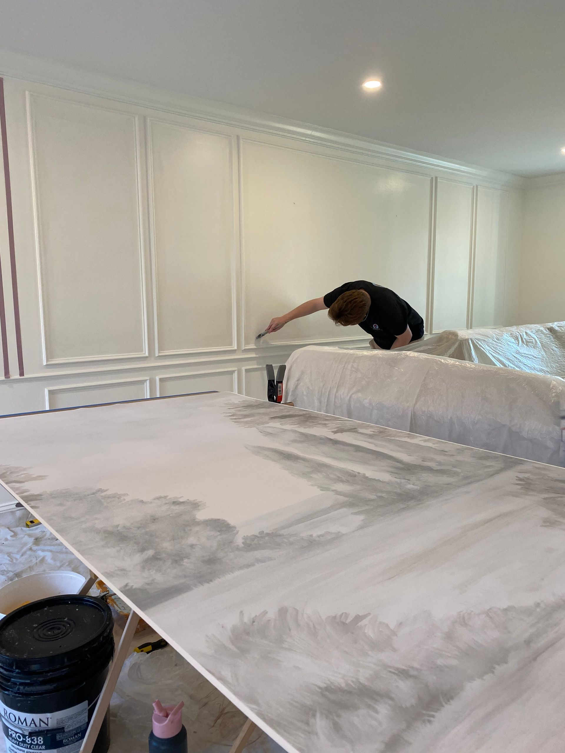 A person is painting a wall in a room.