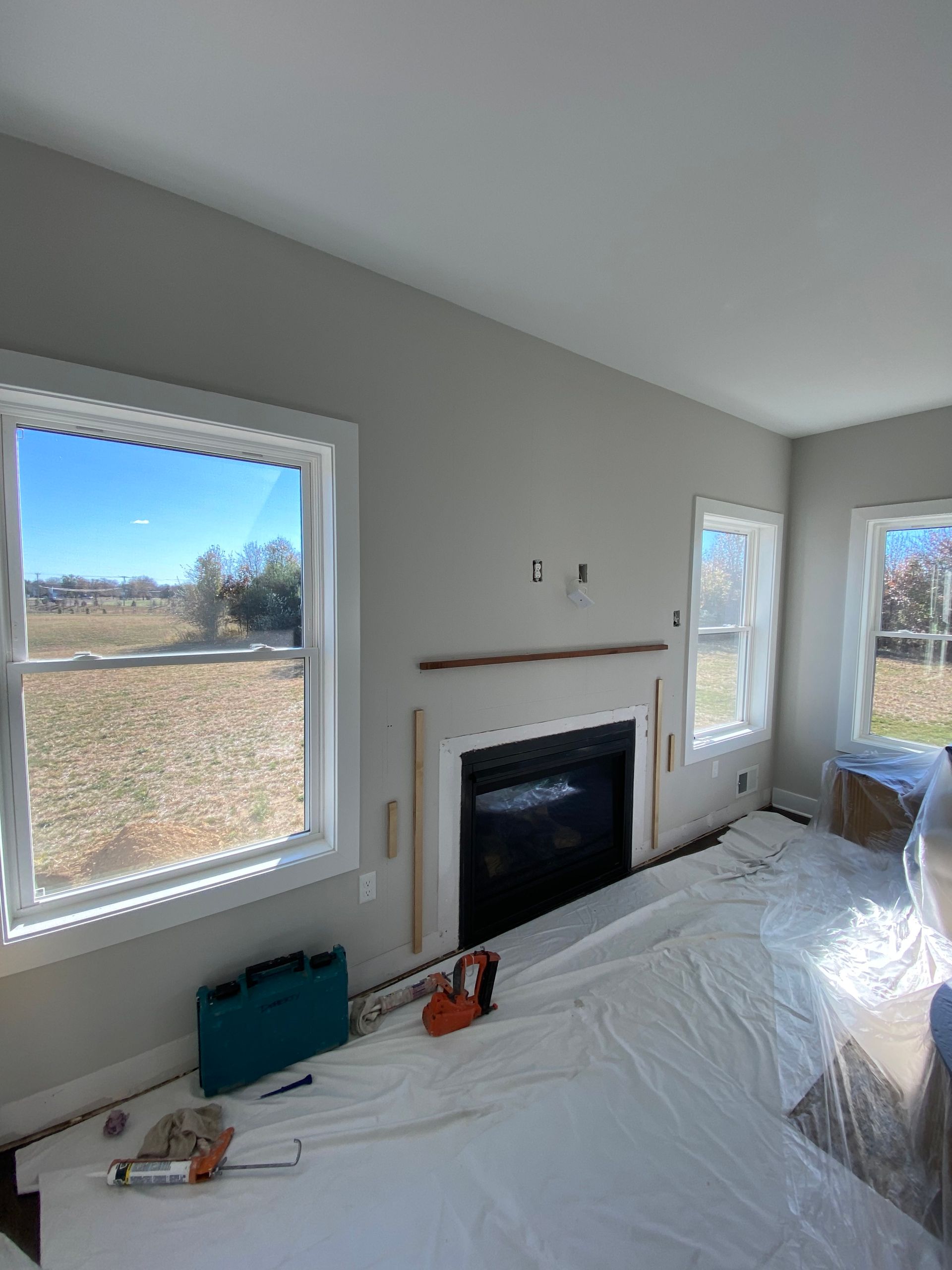 A living room with a fireplace and a lot of windows.