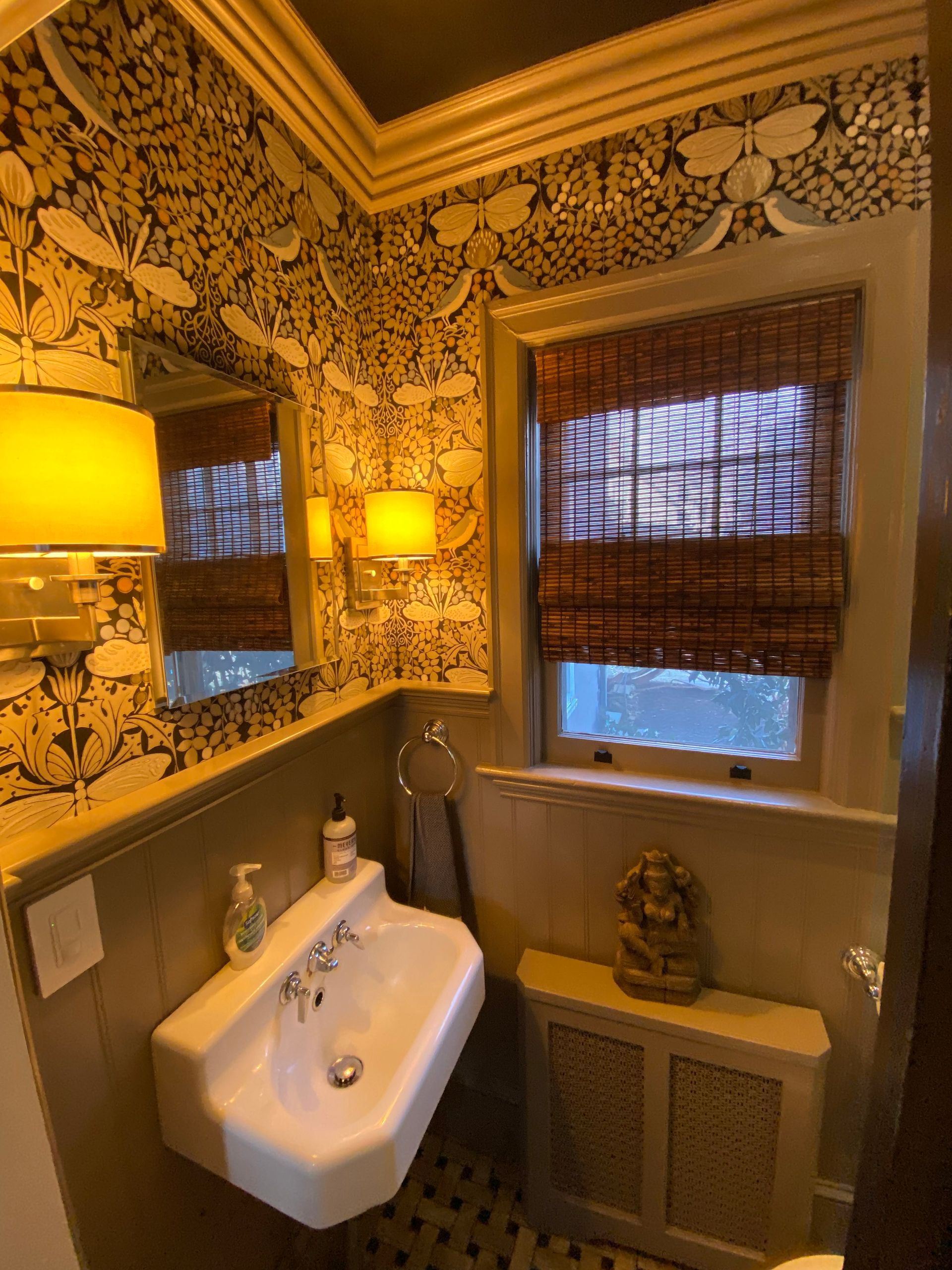 A bathroom with a sink , mirror , and window.