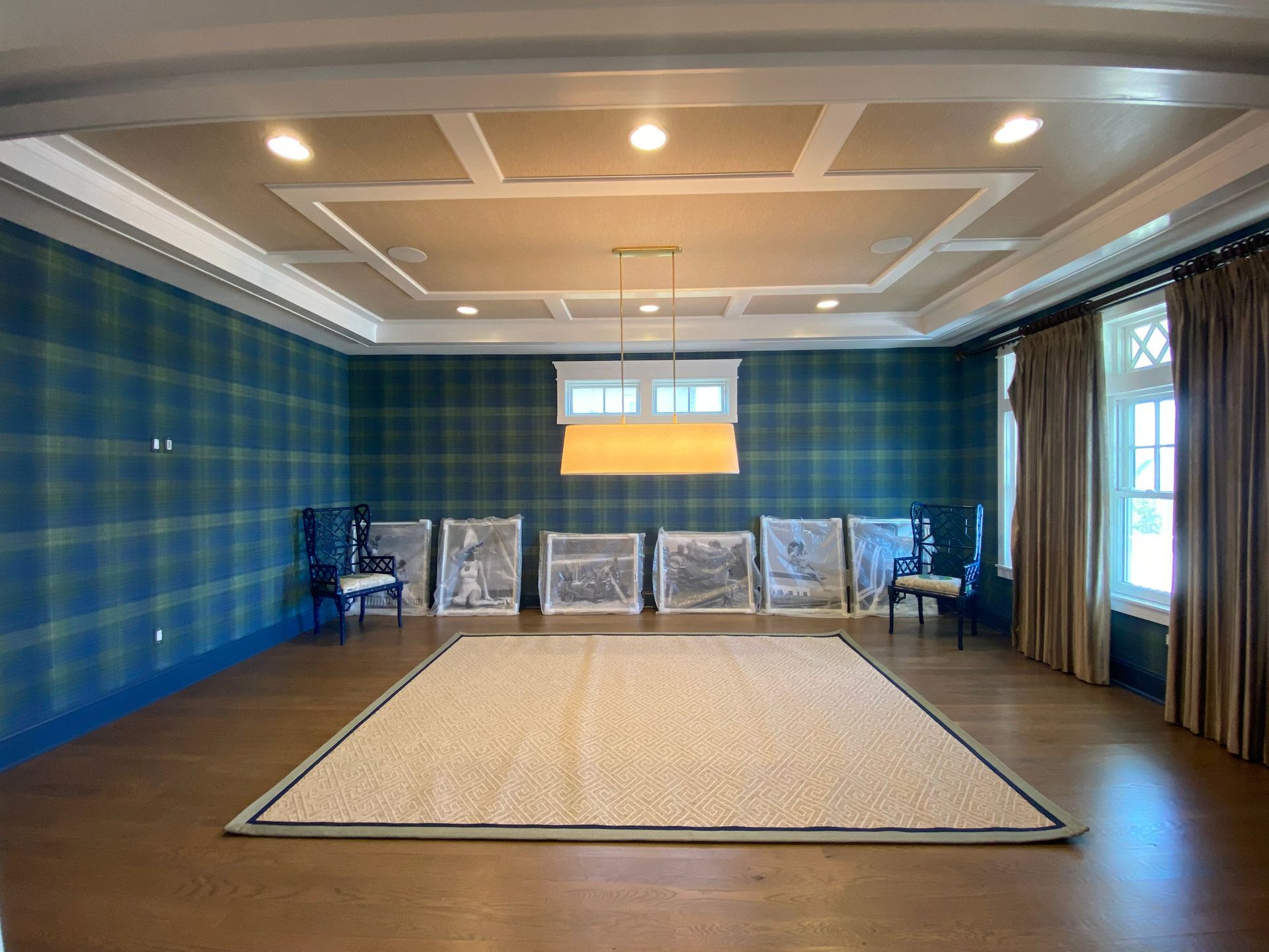 A large room with a rug on the floor and a chandelier hanging from the ceiling.