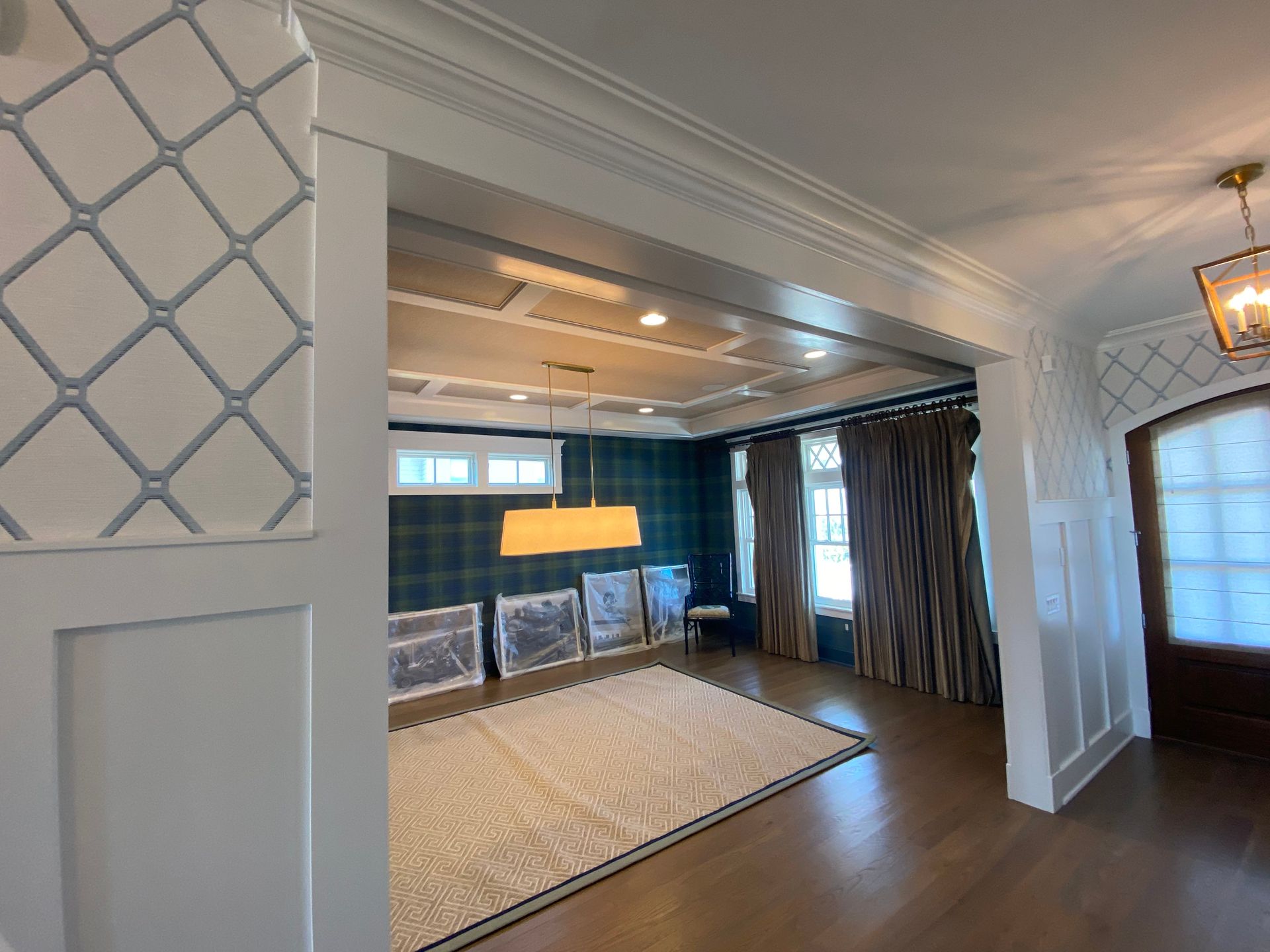 A living room with a rug on the floor and a ceiling fan.