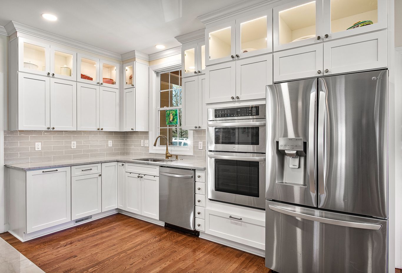 One of our completed kitchen projects with white cabinets, granite countertops and a beautiful shelving system