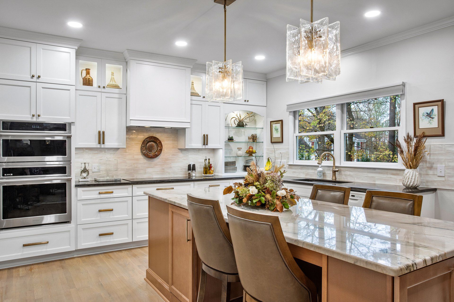 Kitchen Remodeler in RVA: A kitchen with white cabinets, granite counter tops, stainless steel appliances and a large island.