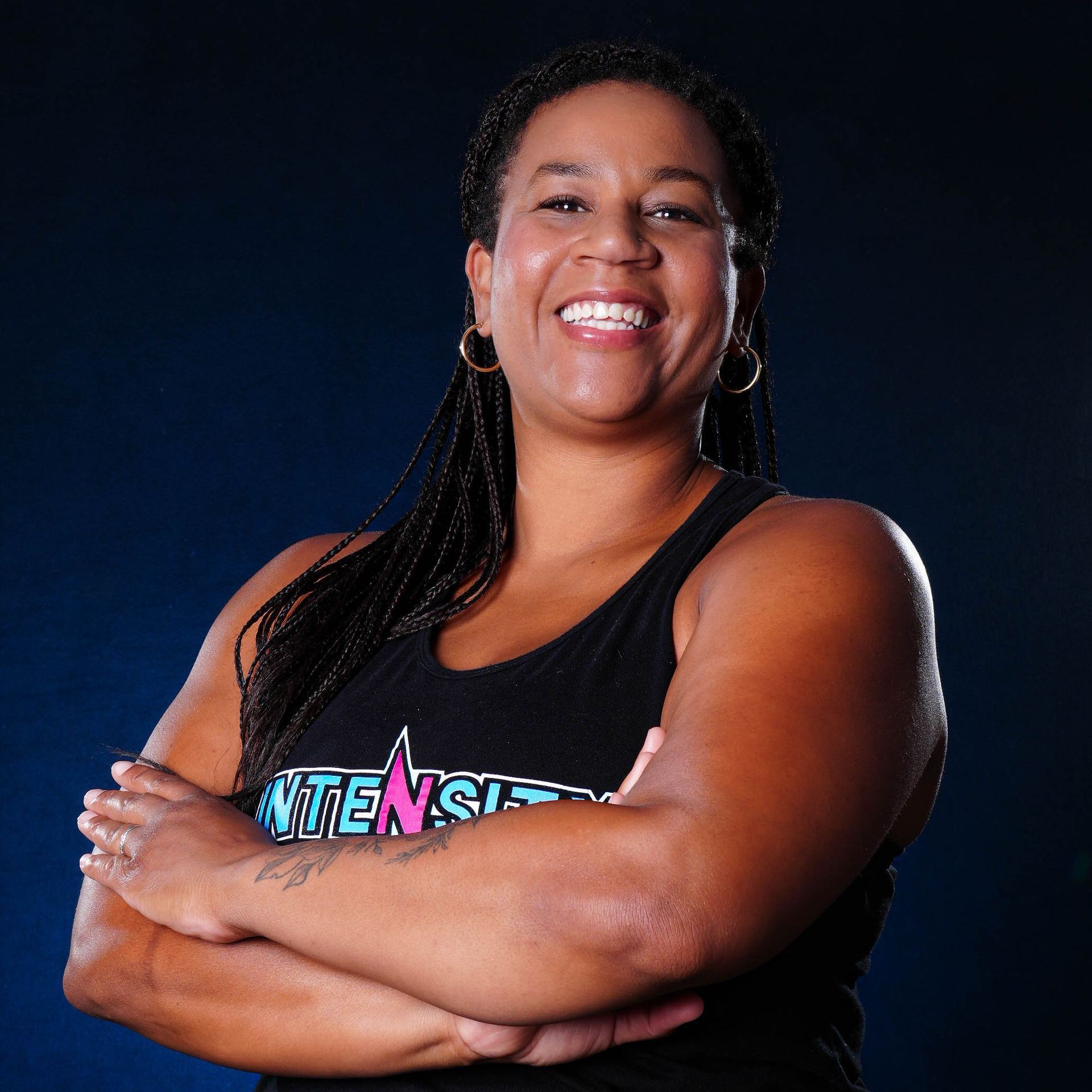 A woman wearing a black tank top with intense written on it