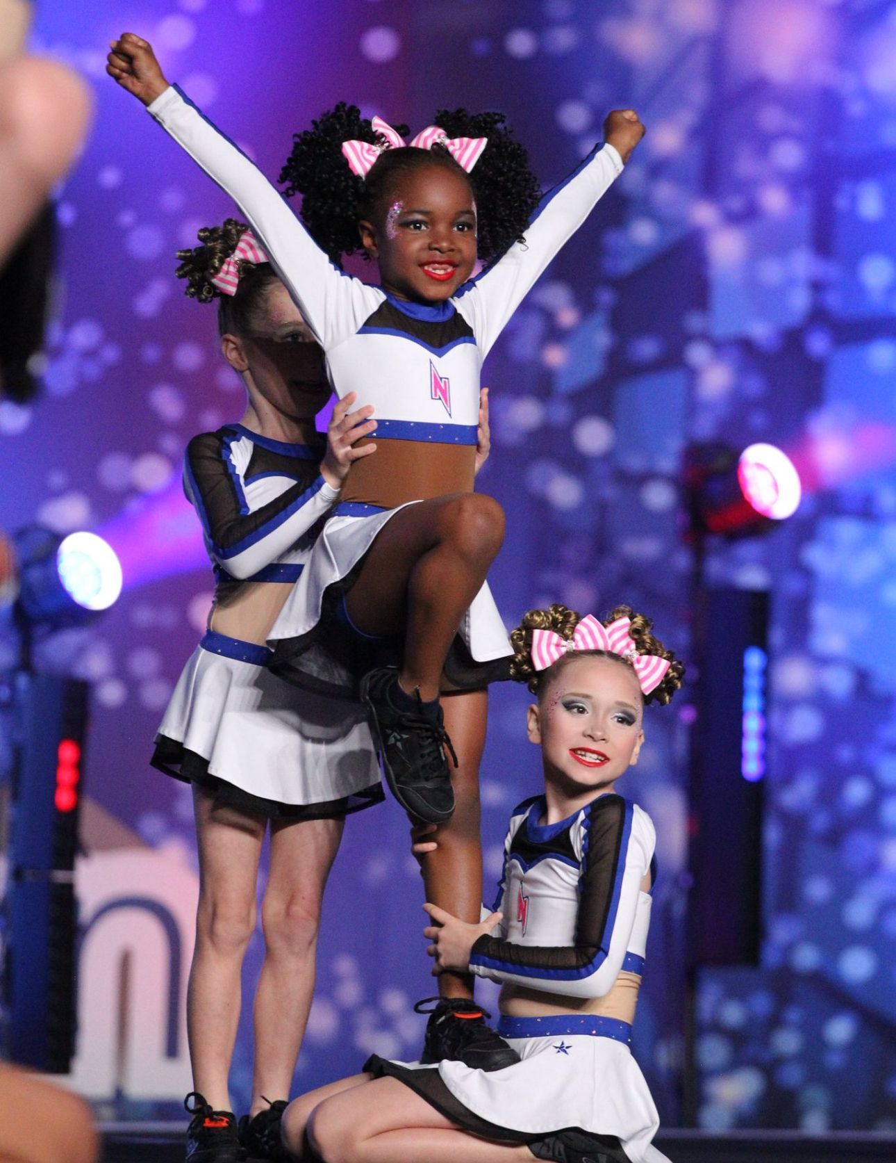 A group of cheerleaders are performing on a stage.