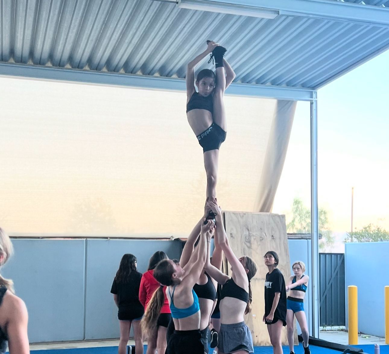 A cheerleader is doing a split in the air