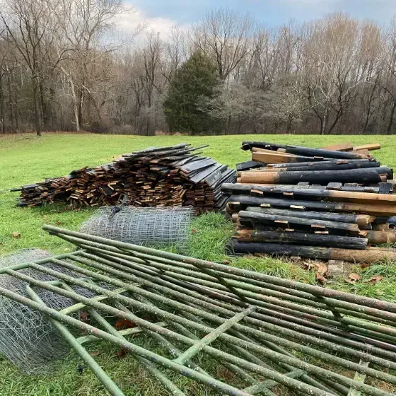 a pile of wood is sitting on top of a lush green field .