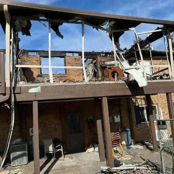 a house that has been damaged by a fire and has a deck .