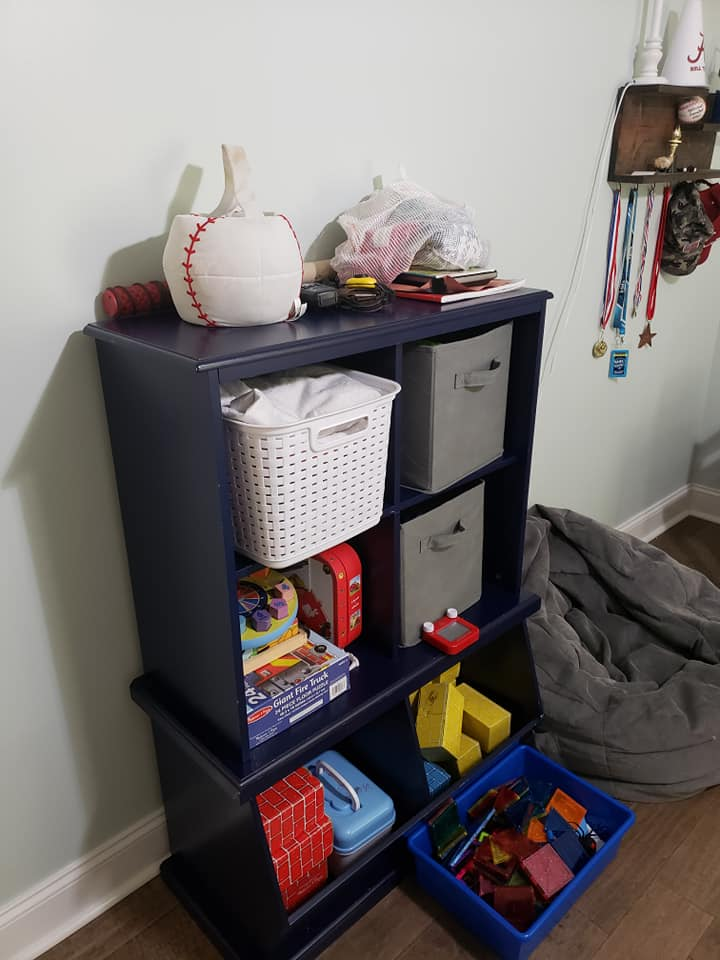 Blue shelf unit with toys, a baseball, and storage bins.