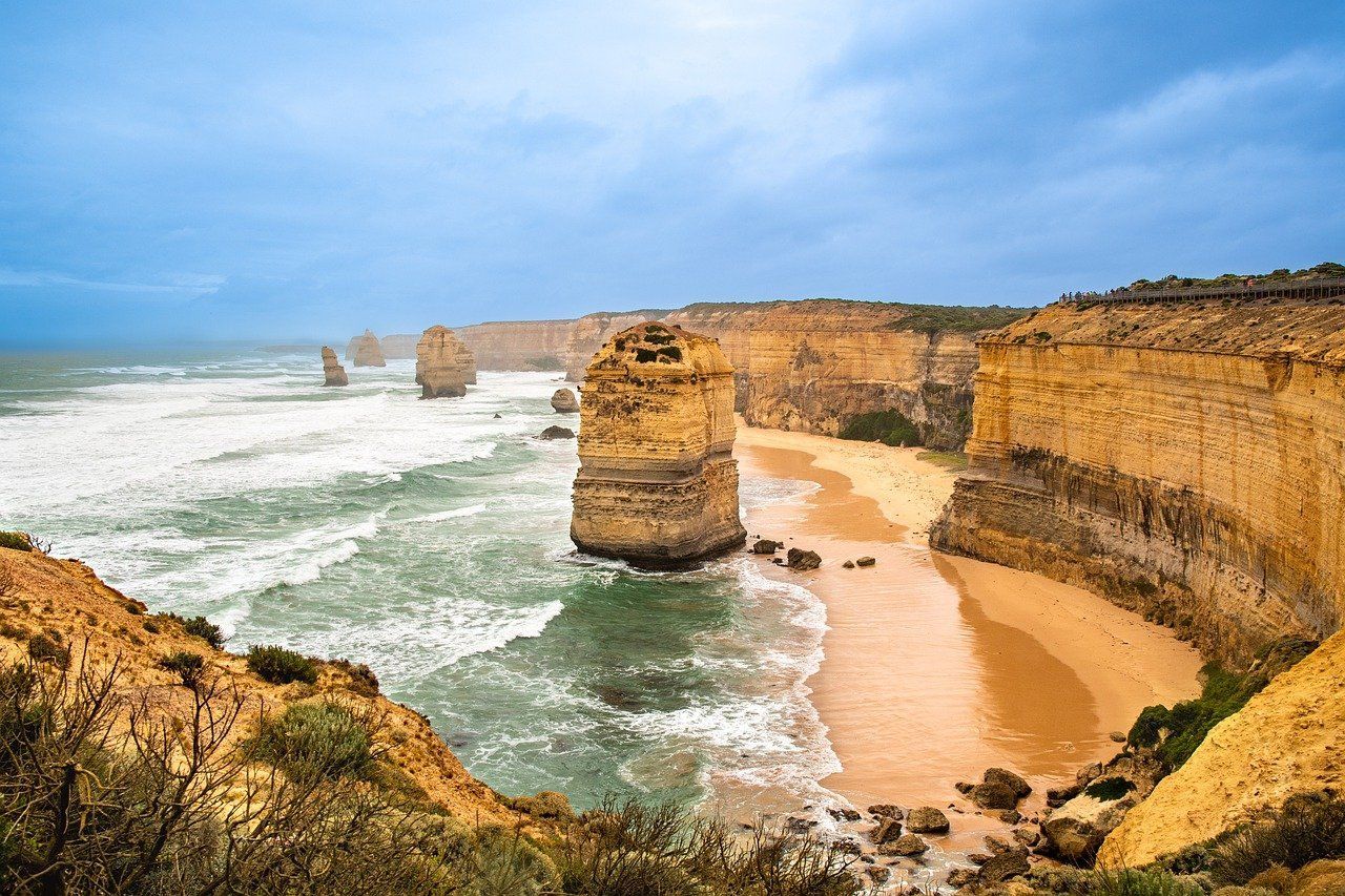 A beach surrounded by cliffs and rocks next to the ocean.