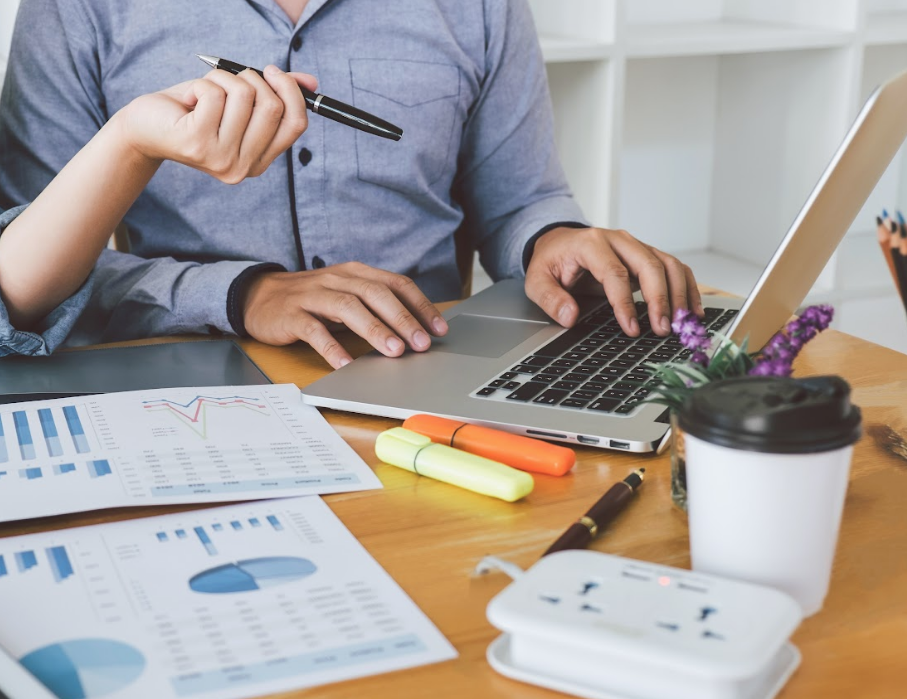 Pricing for our different bookkeeping packages - man working on laptop with graphs