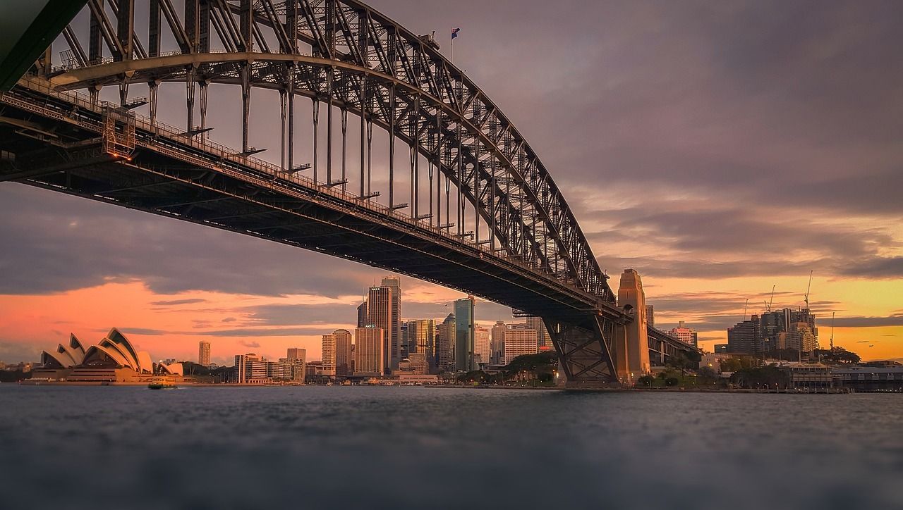 A bridge over a body of water with a city in the background