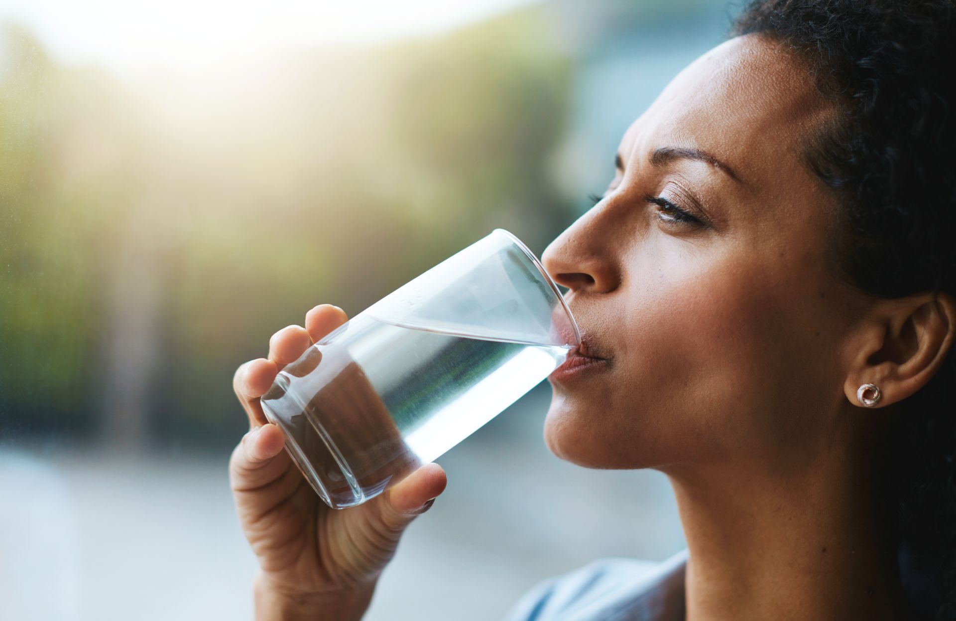 Woman enjoying clean water at home with drinking water systems in Anderson, IN, improving taste, qua