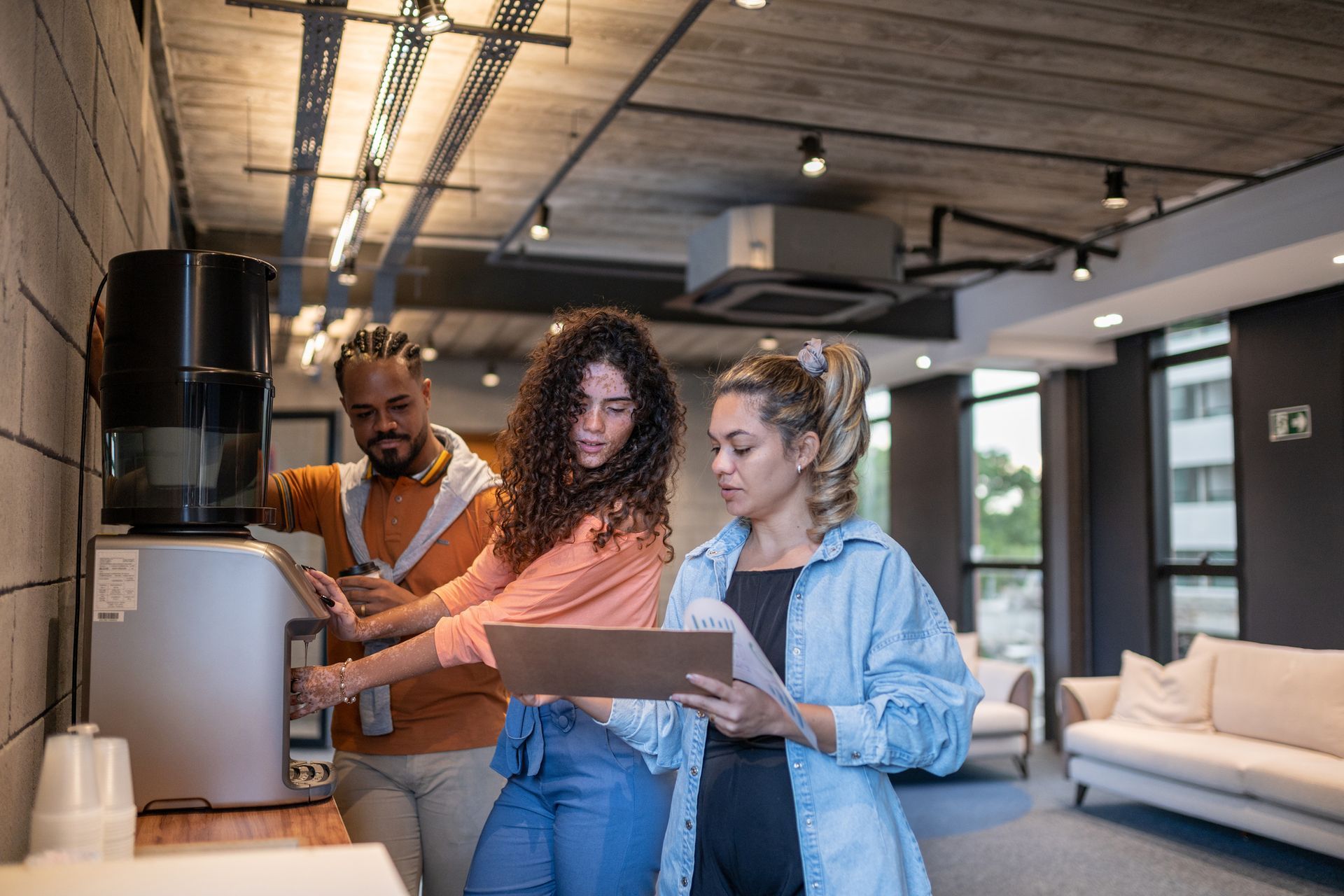 A girl is getting water while talking to her teammates.