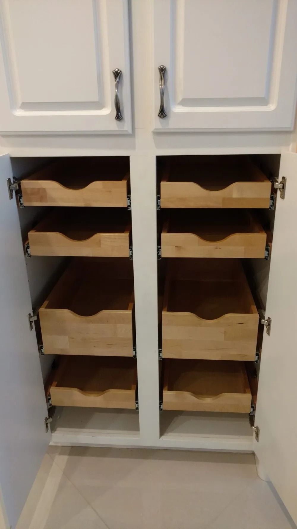 The drawers are made of wood and are pulled out of the cabinet.