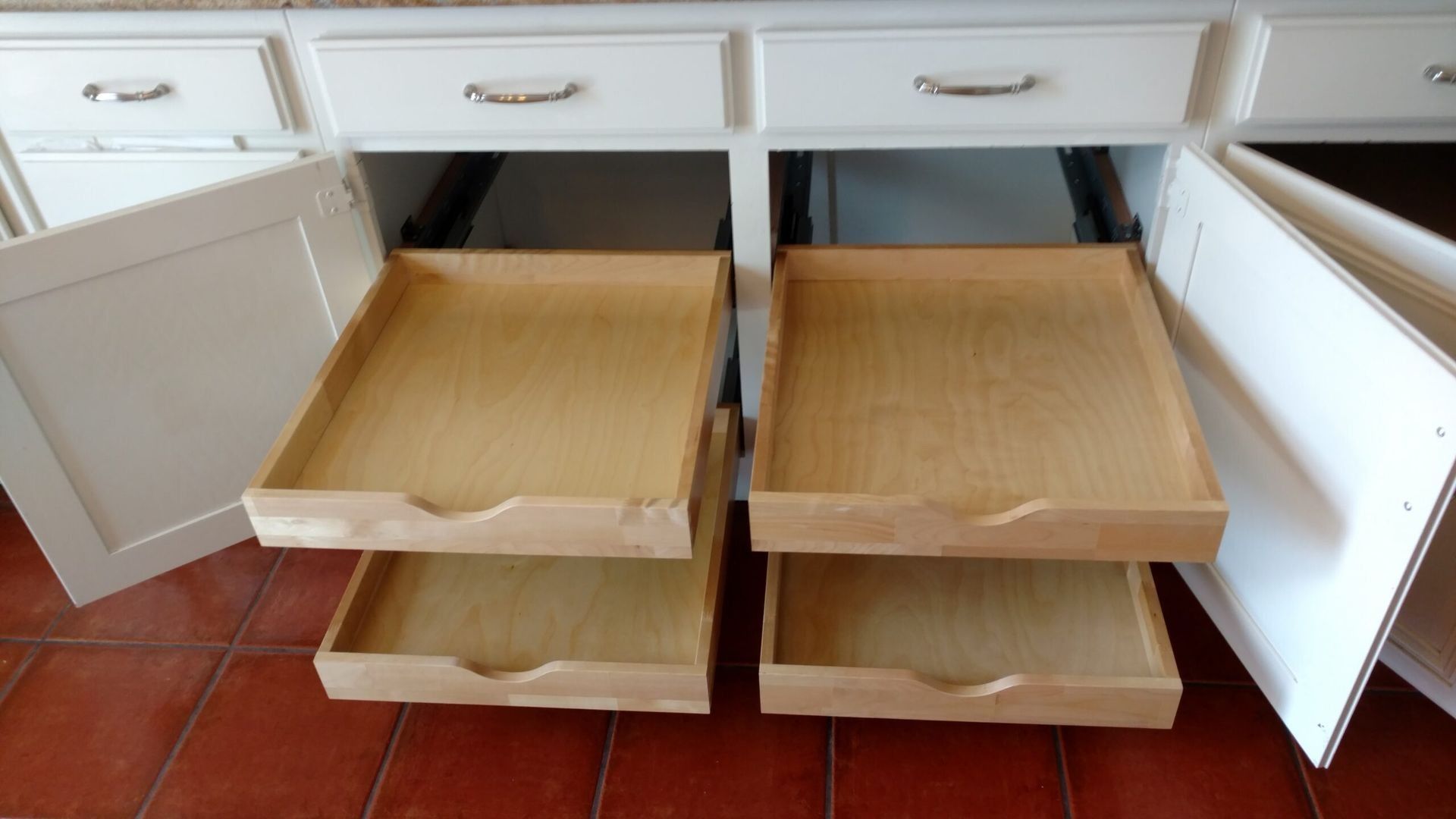 Two wooden drawers are pulled out of a cabinet