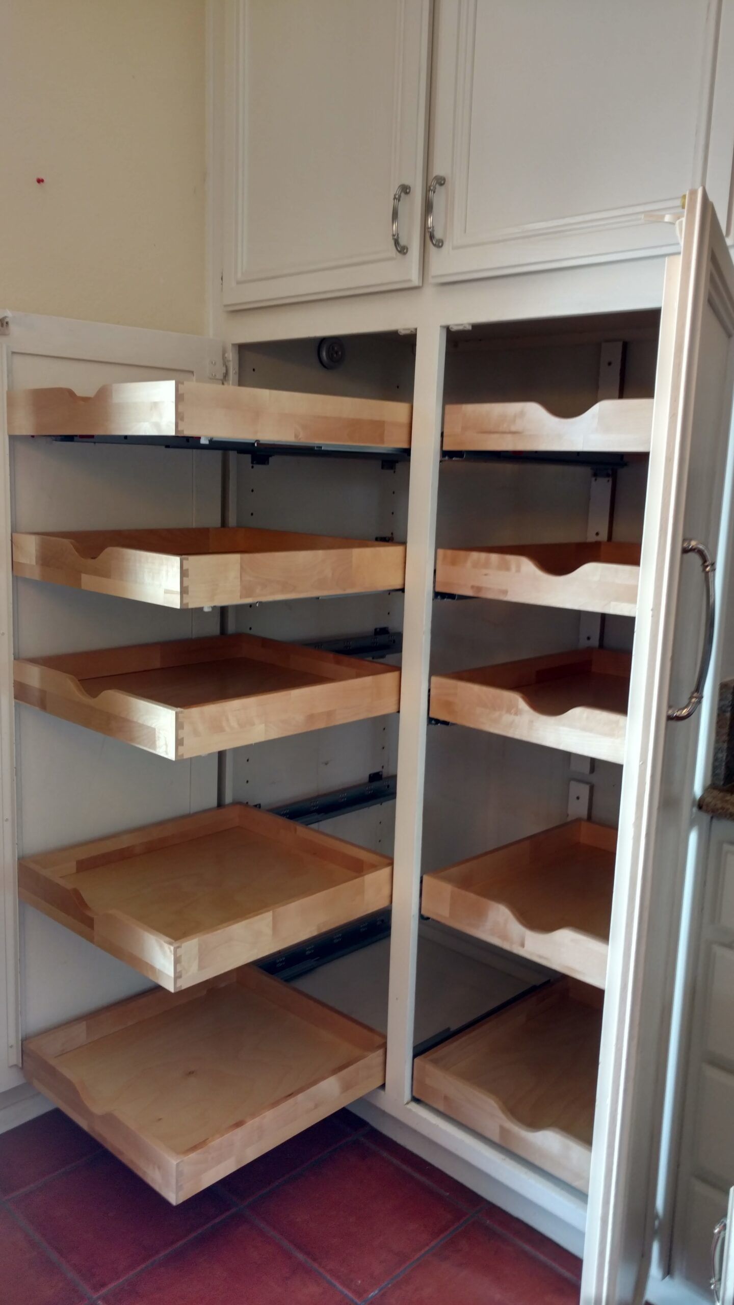 A pantry with lots of wooden shelves and drawers