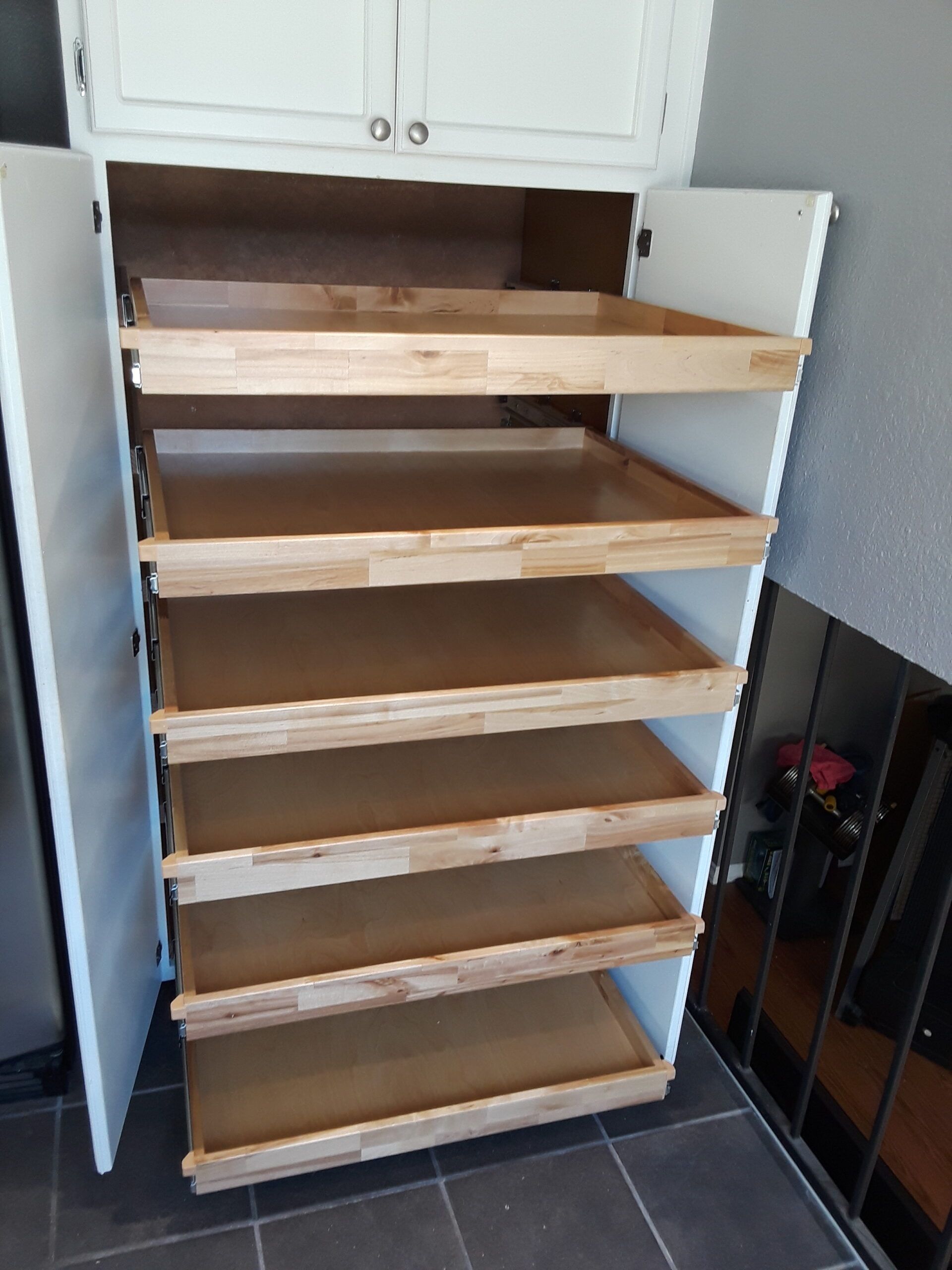 A white cabinet with wooden shelves and drawers