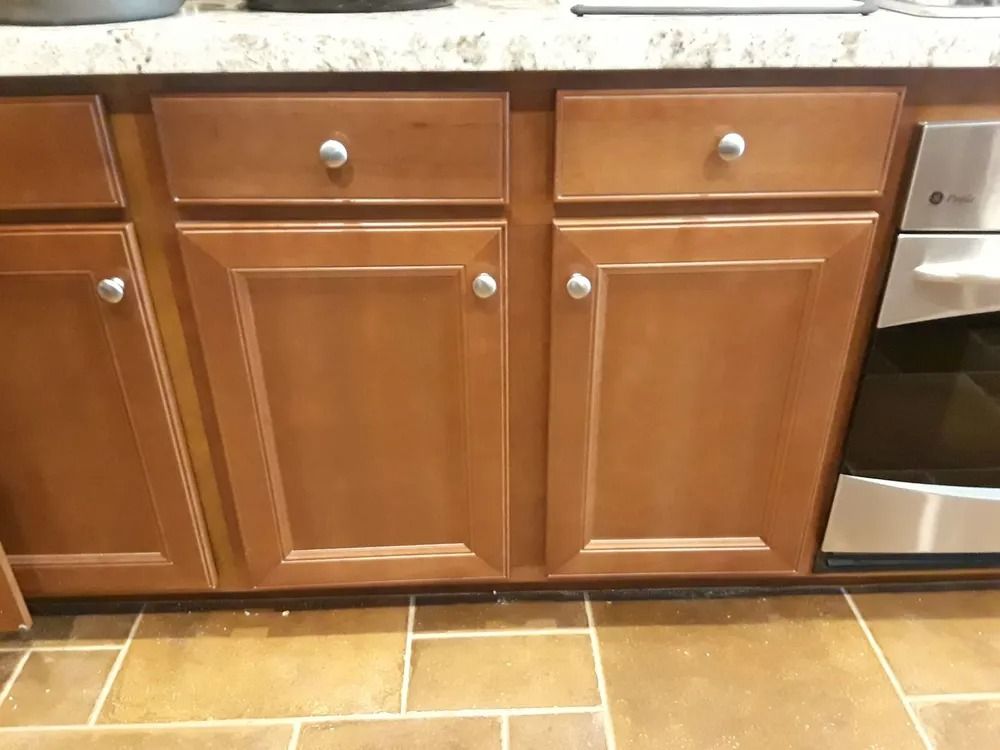 A kitchen with wooden cabinets and a stainless steel oven.