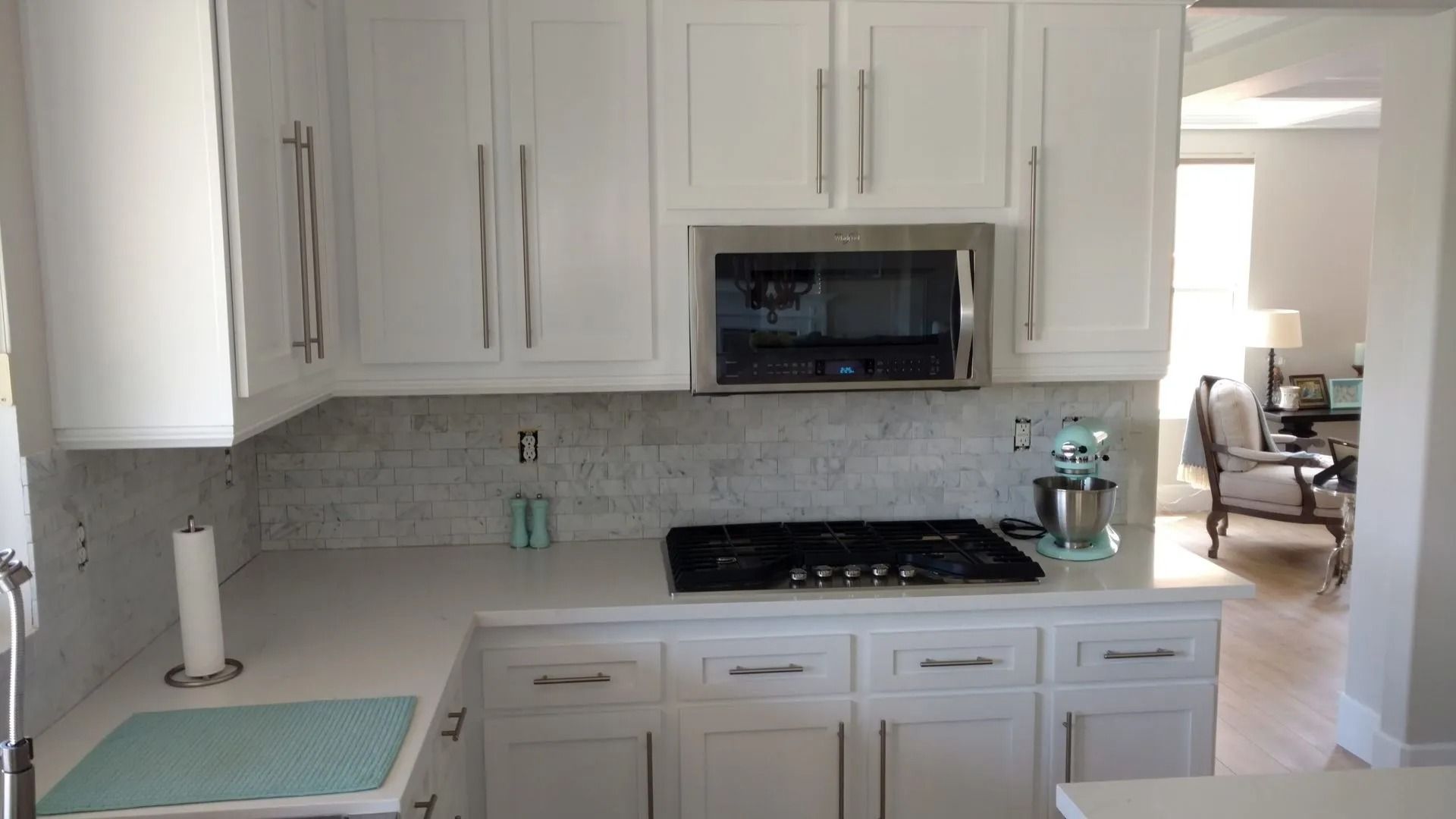 A kitchen with white cabinets and a stove top oven