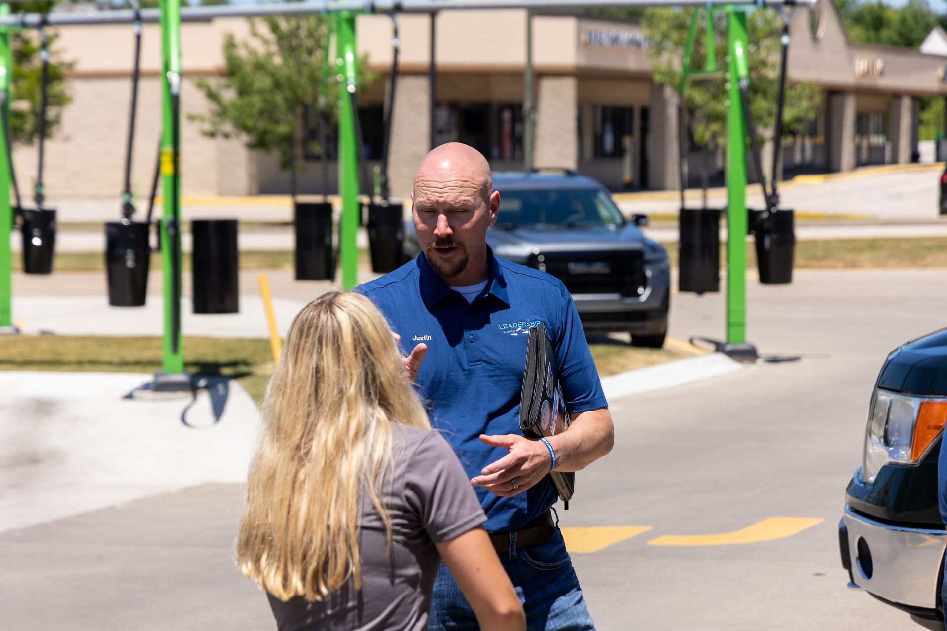 A man is talking to a woman in a parking lot.