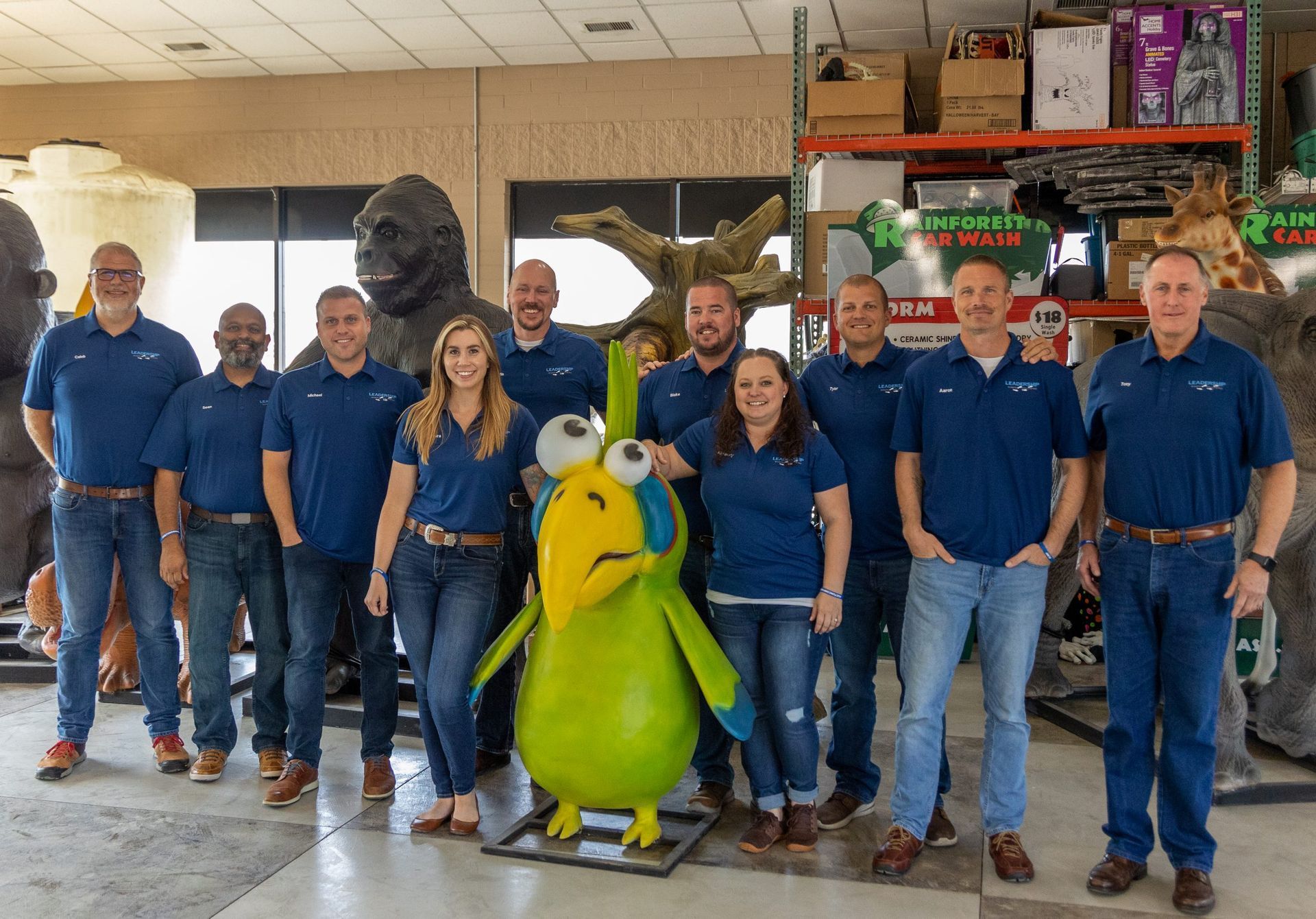 A group of people are posing for a picture with a stuffed animal.