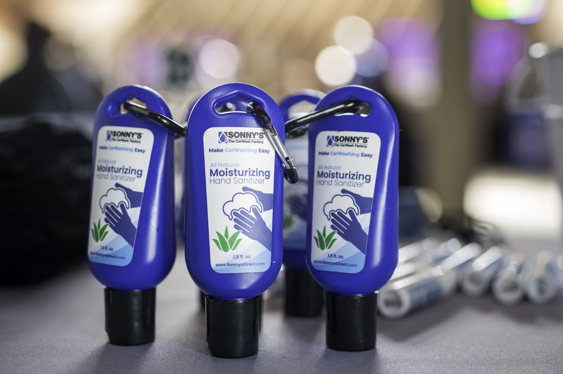 Three bottles of hand sanitizer are sitting on a table.