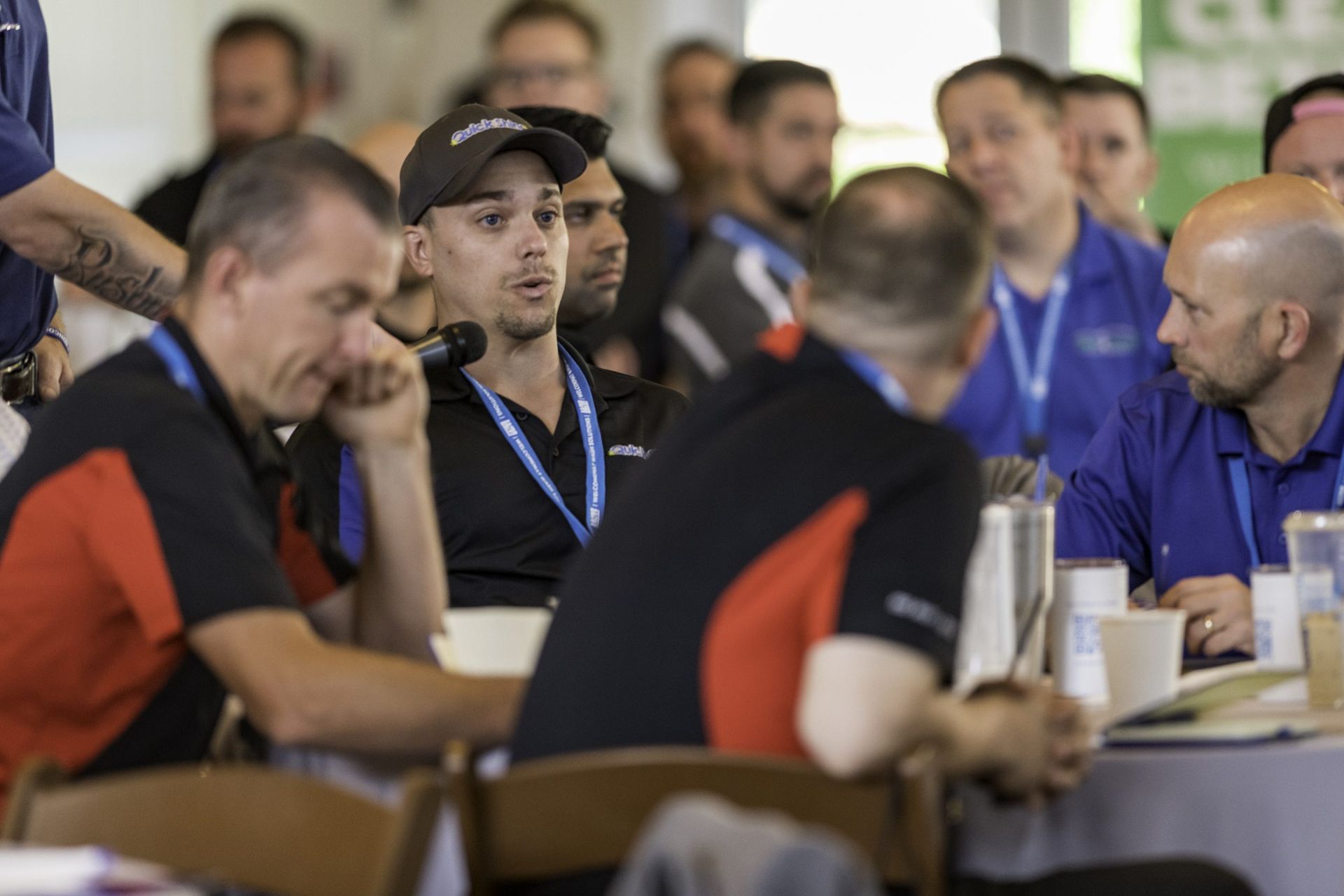 A group of men are sitting at a table talking to each other.