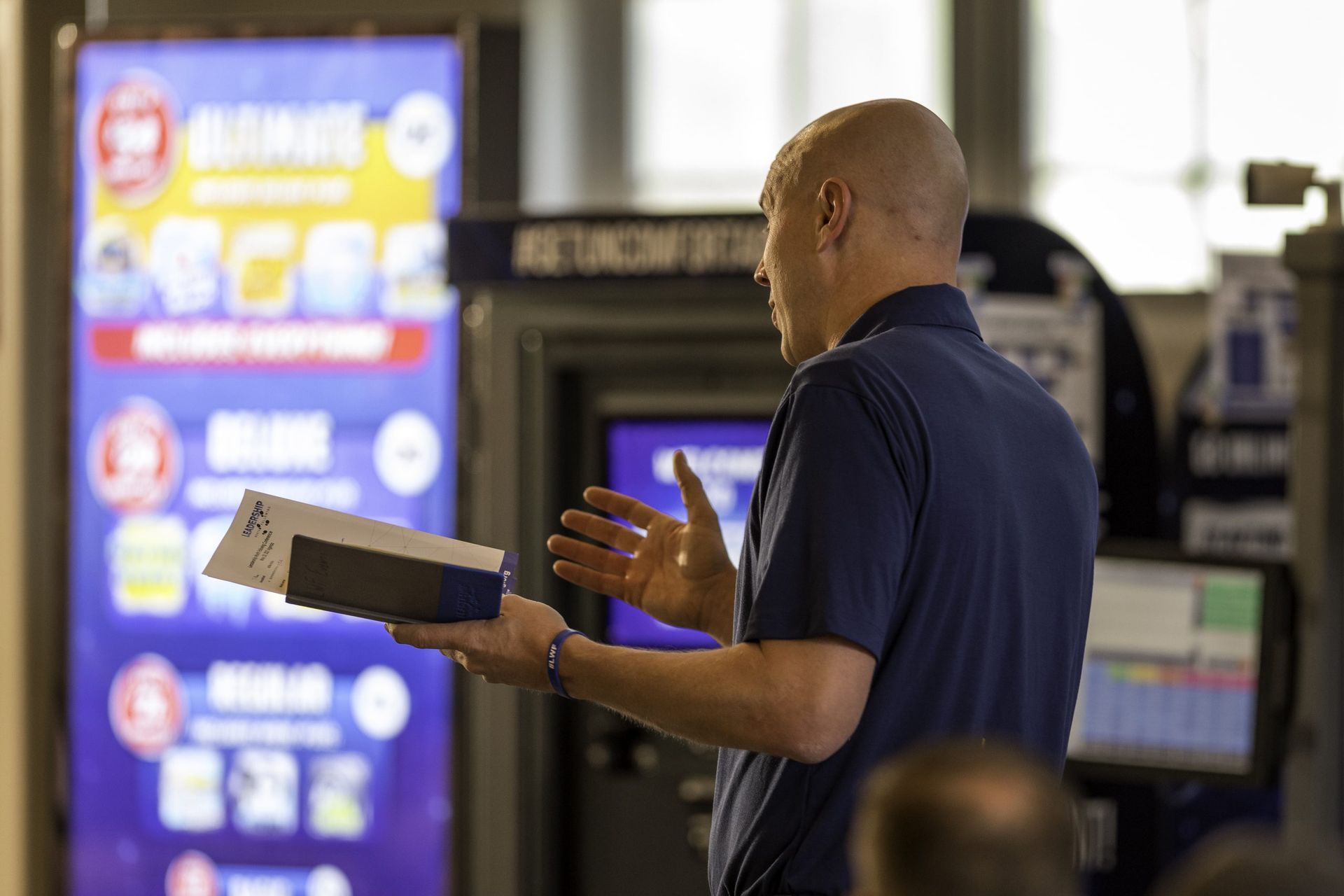 A man is standing in front of a machine holding a box.