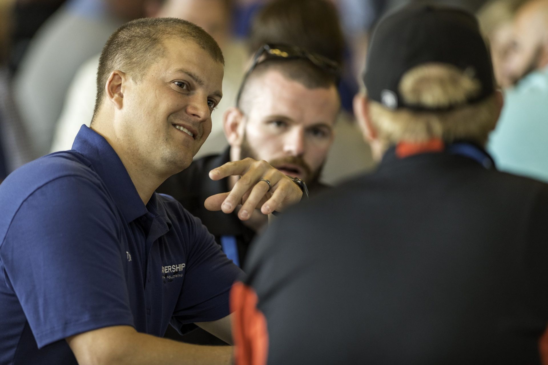 A group of men are sitting at a table talking to each other.