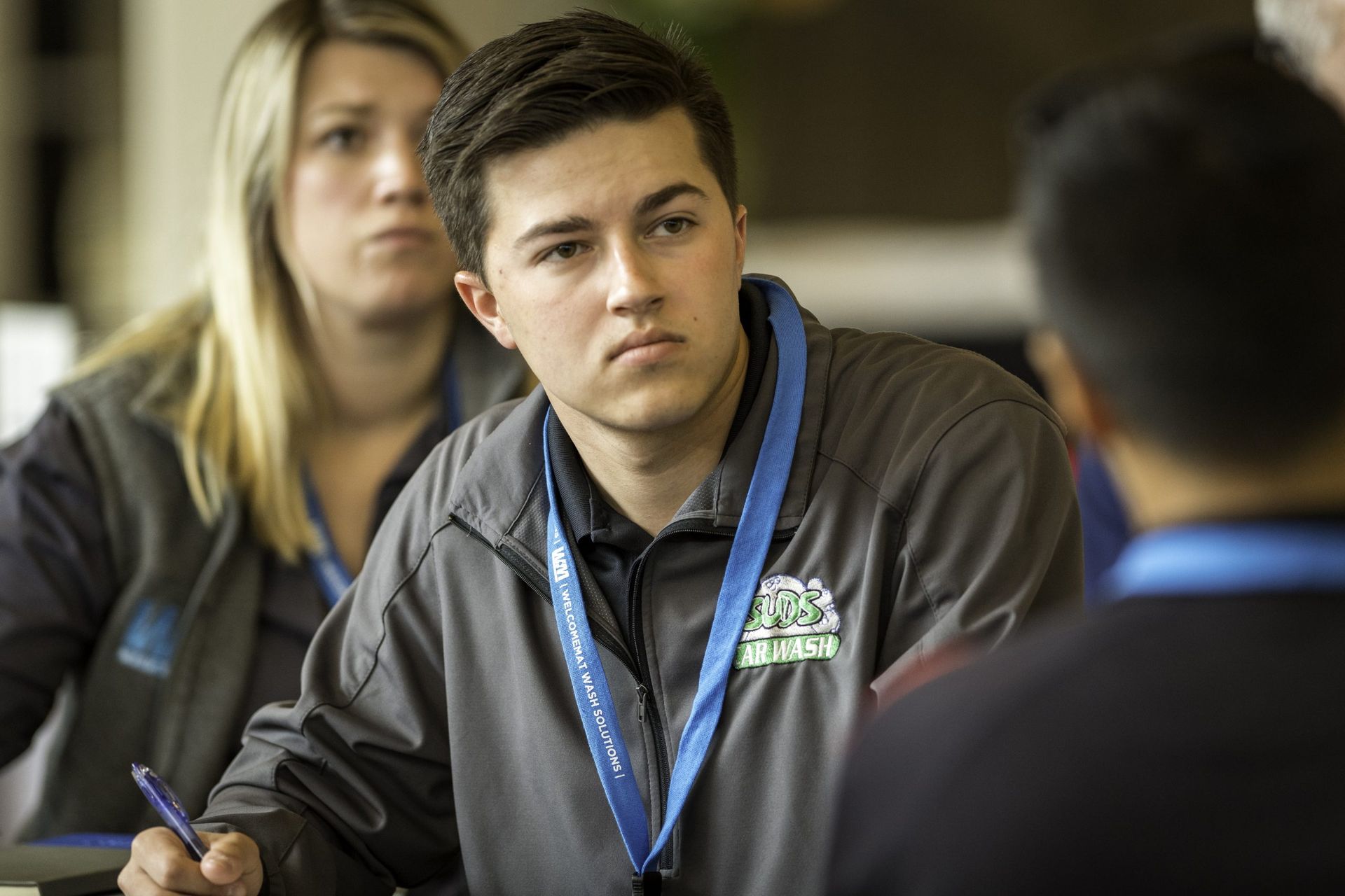 A man is sitting at a table with a pen in his hand.