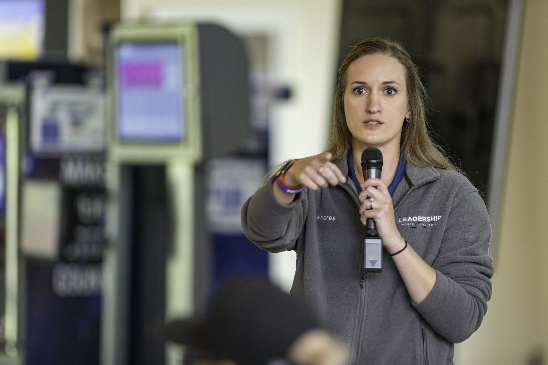 A woman is holding a microphone and talking into it.