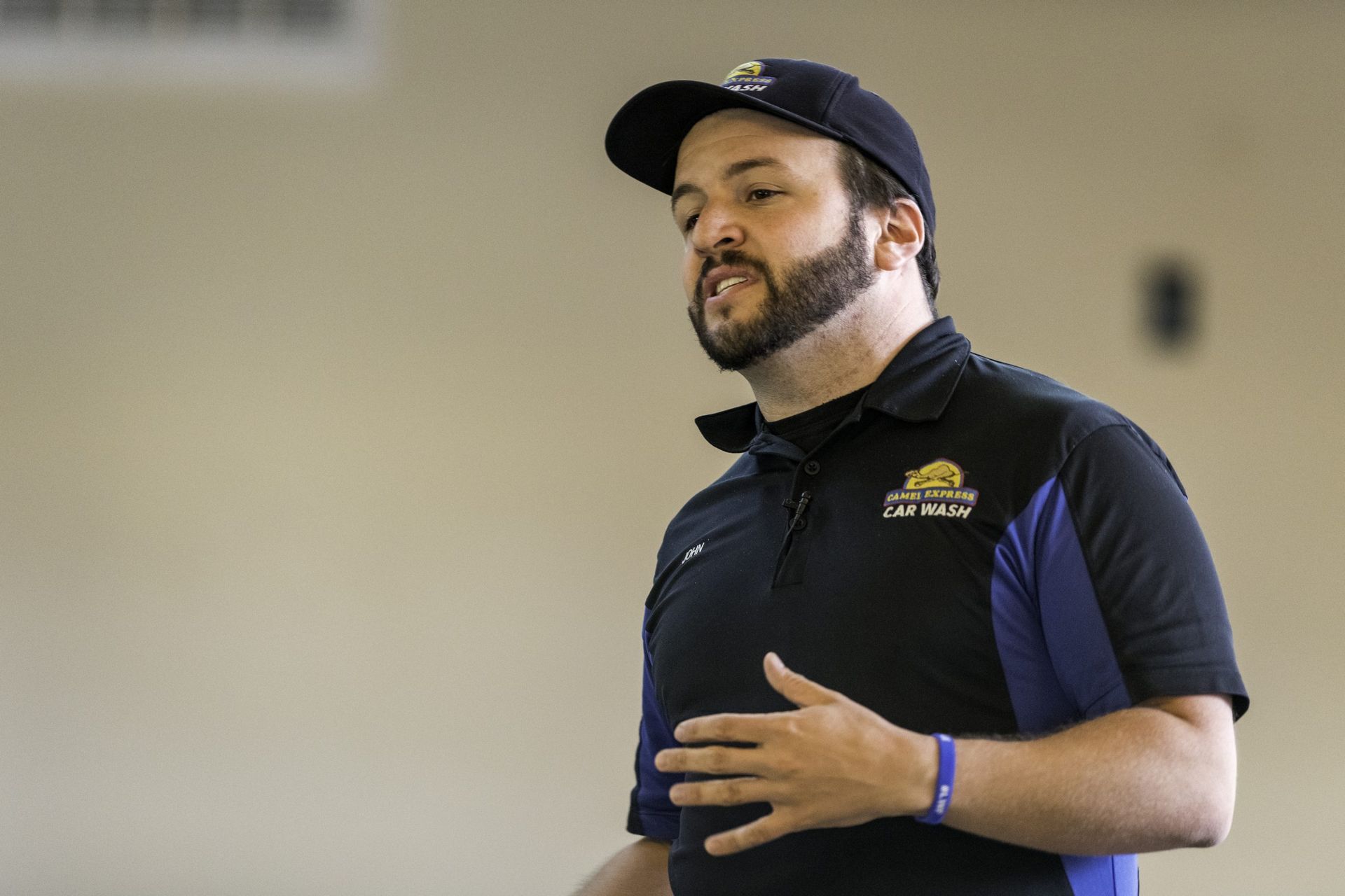 A man with a beard is wearing a hat and a black shirt.