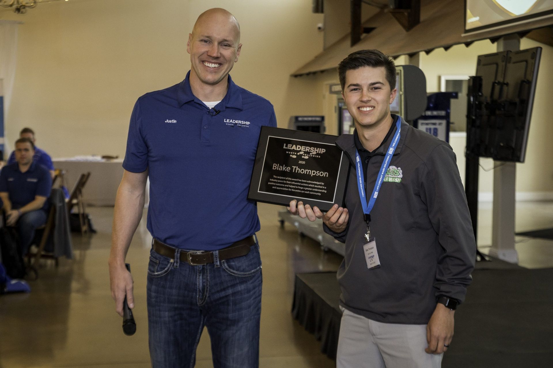 Two men are standing next to each other holding a plaque.