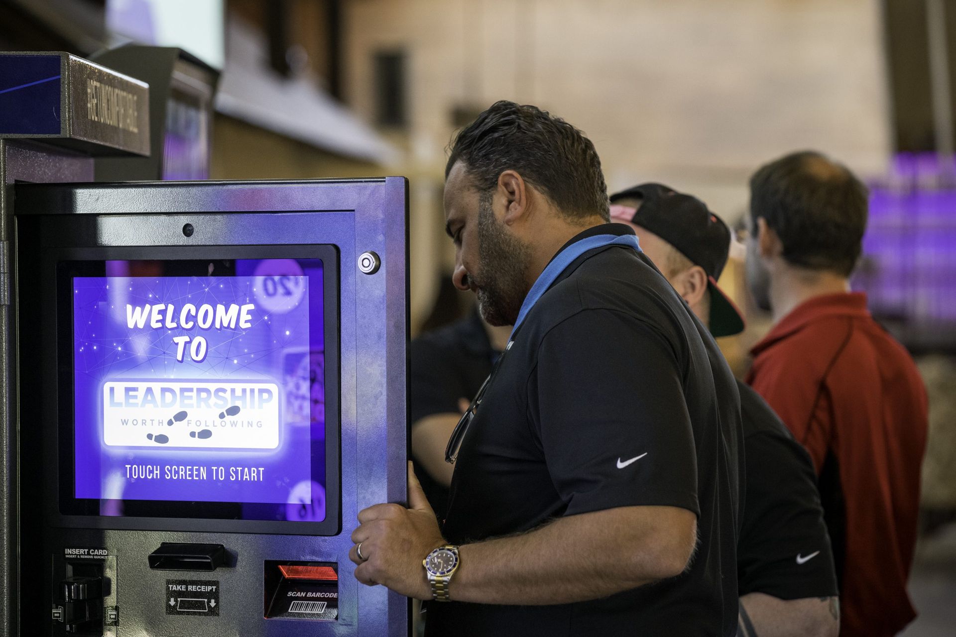 A man is using a machine that says welcome to leadership