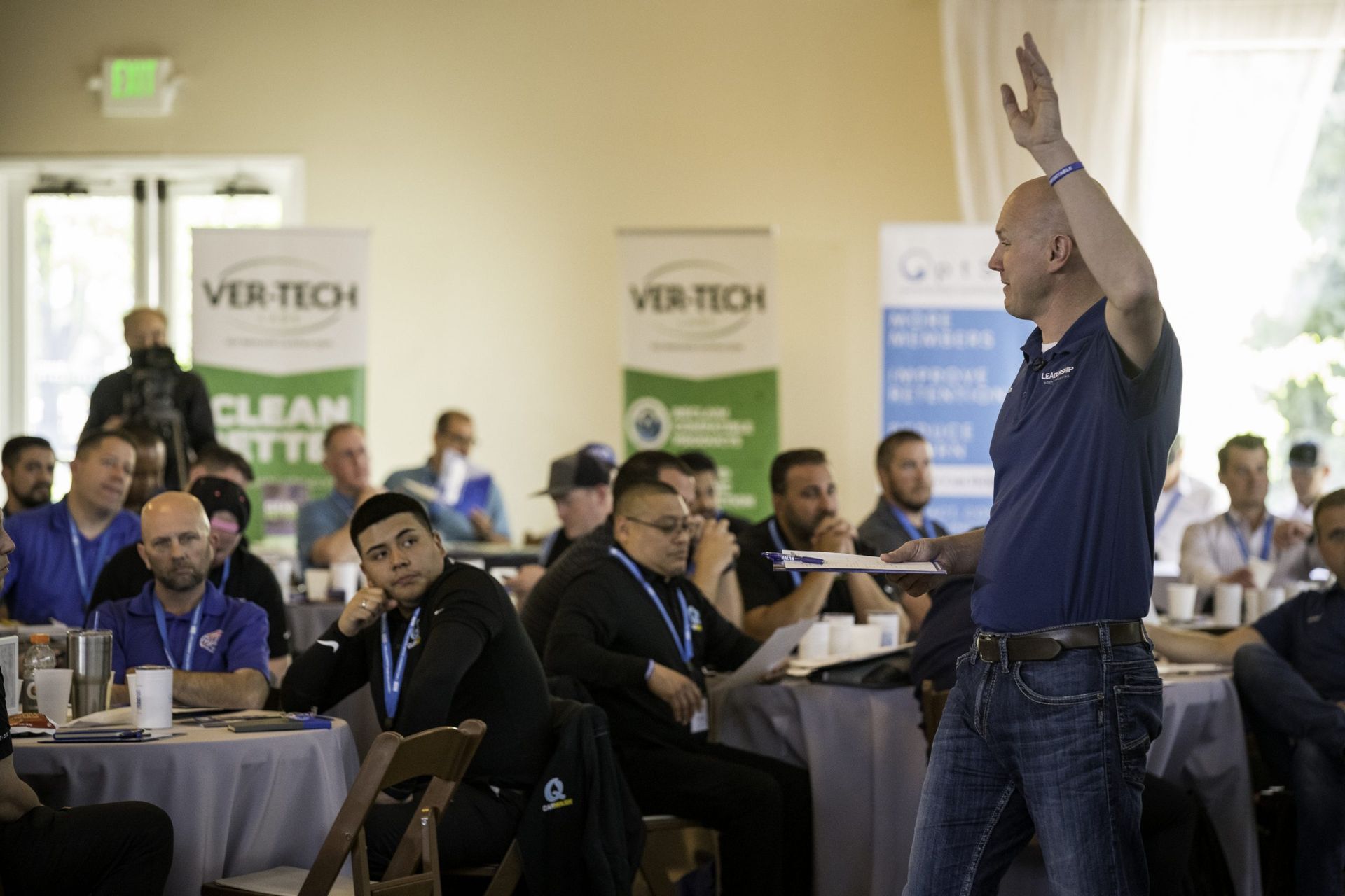 A man is standing in front of a group of people at a conference.