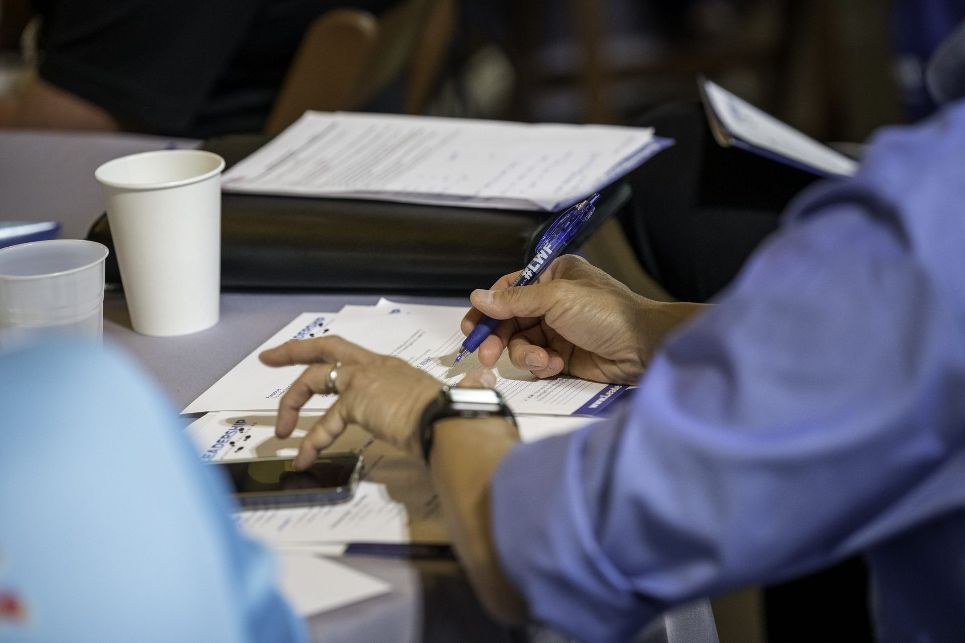 A person is writing on a piece of paper with a pen.