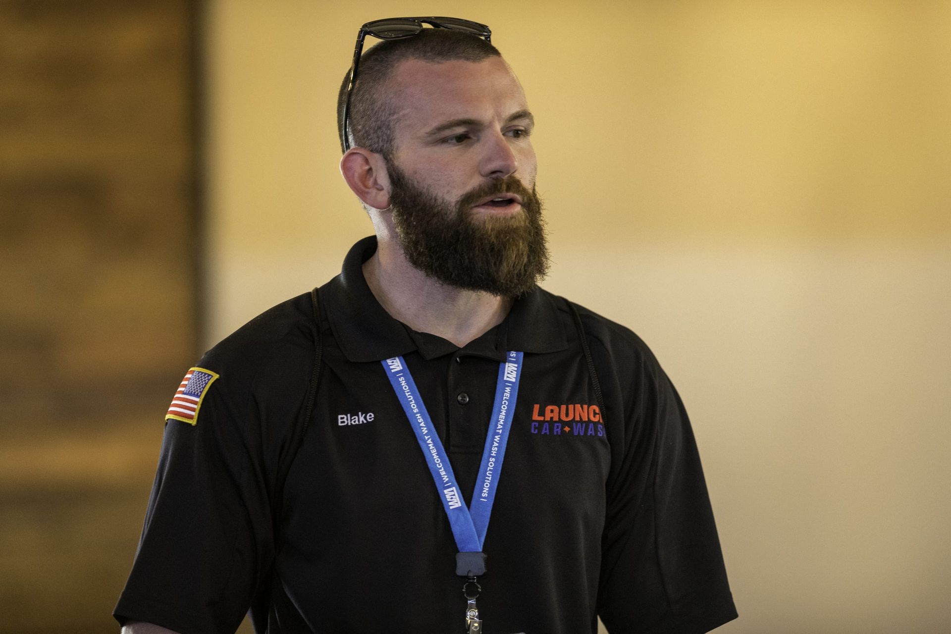 A man with a beard is wearing a lanyard around his neck.
