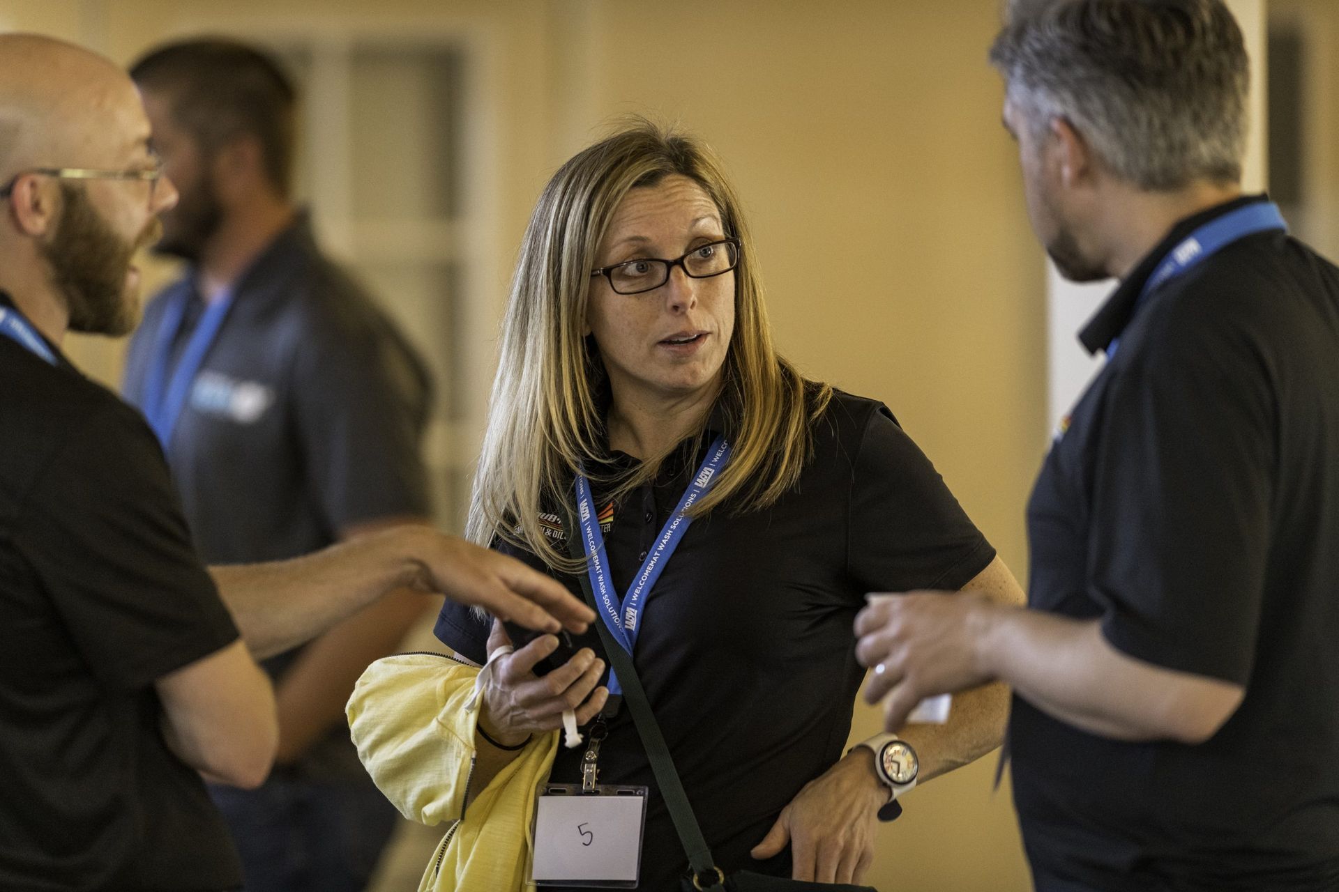 A group of people are standing around talking to each other.