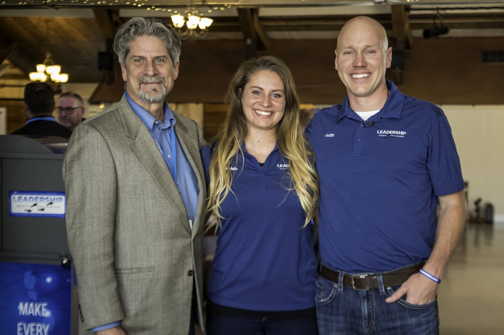 A man , a woman , and a man in a suit are posing for a picture.