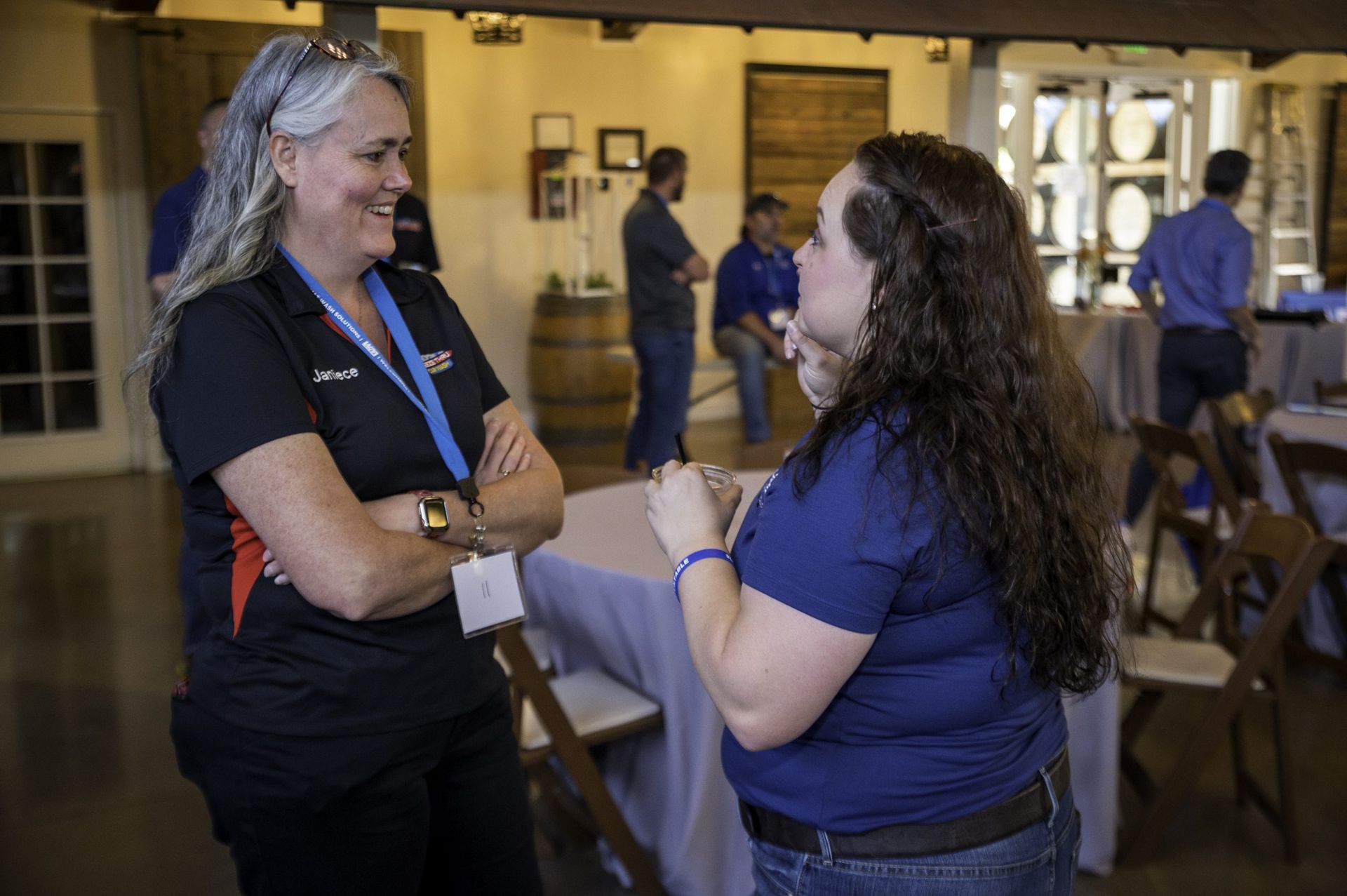 Two women are talking to each other in a room.