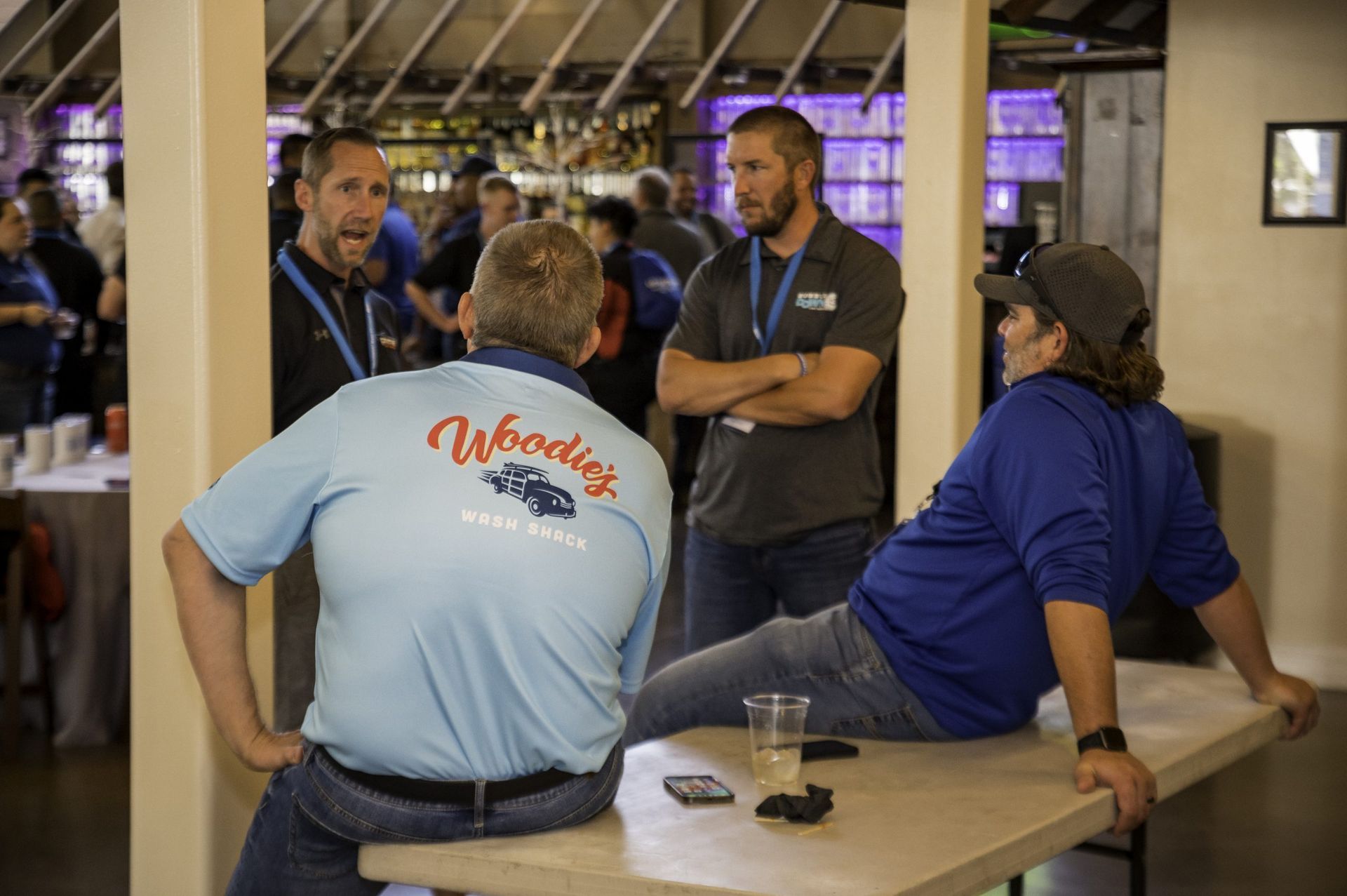 A group of men are sitting at a table talking to each other.