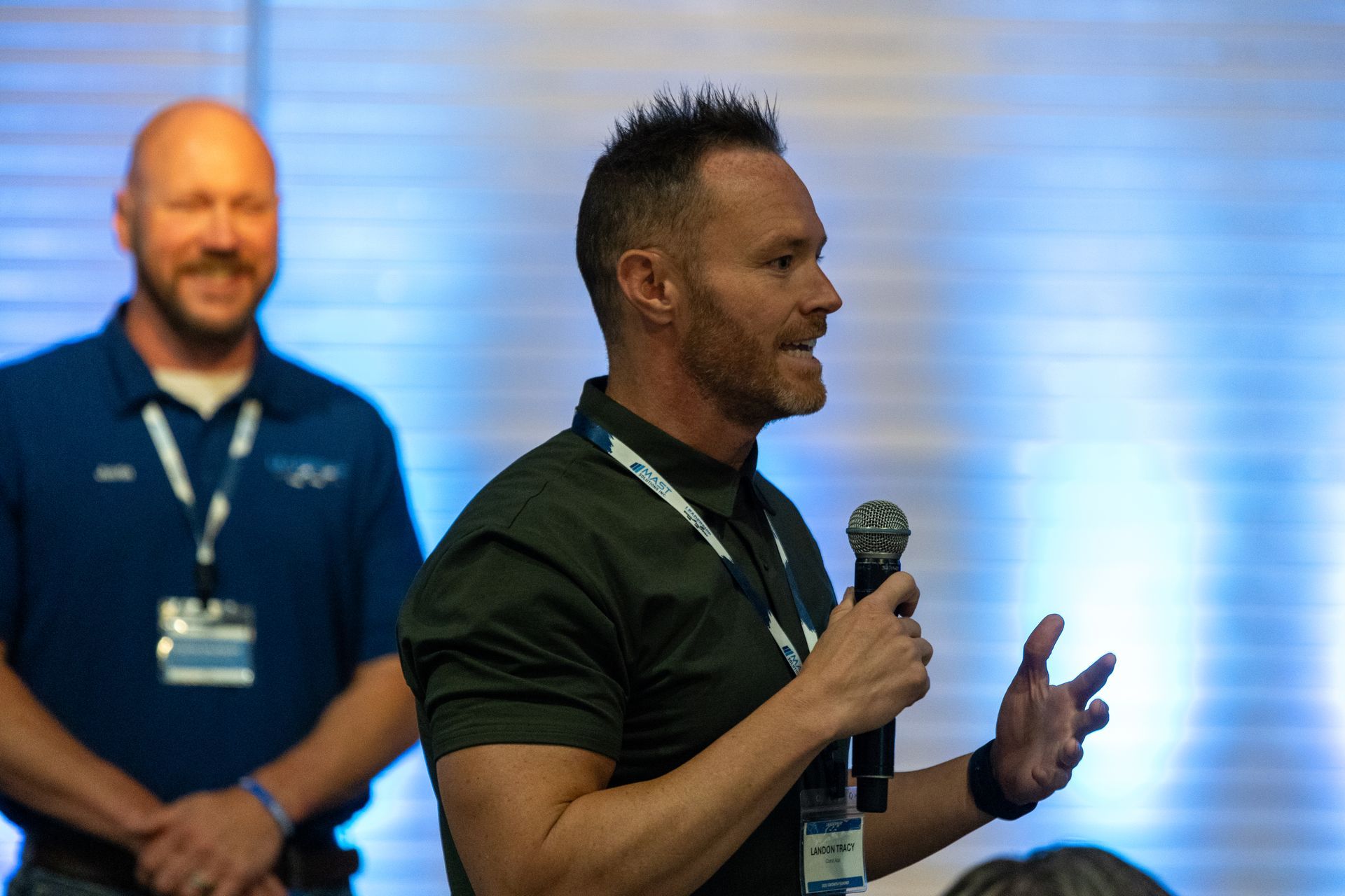 Man speaking into a microphone, at Leadership Worth Following car wash convention