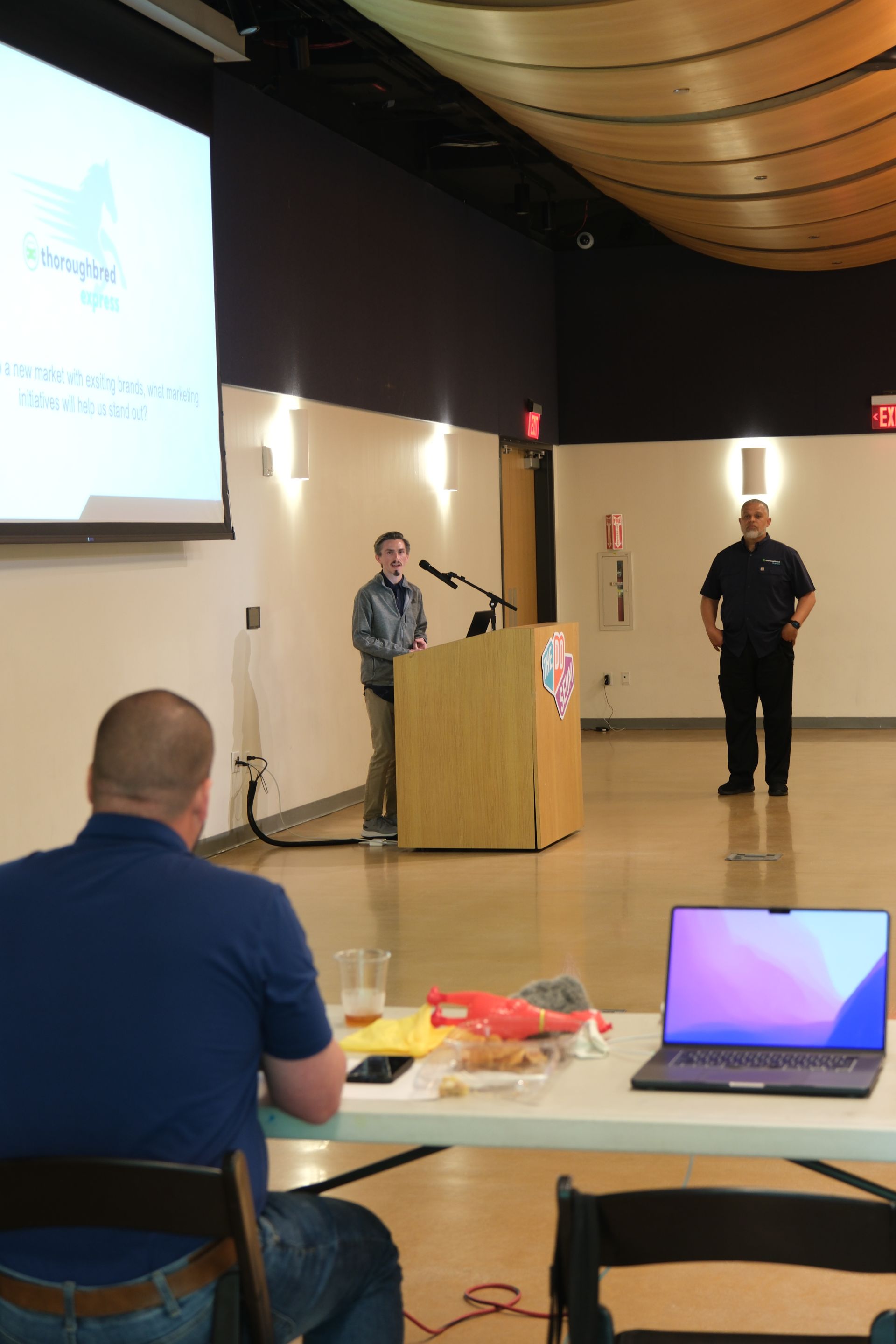 A man giving a presentation in front of a large screen