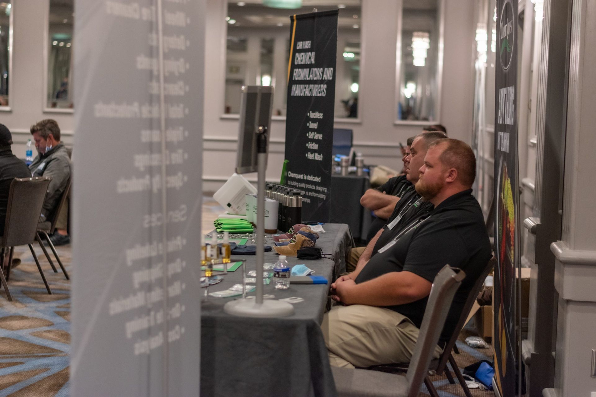 A group of men are sitting at tables in a room.