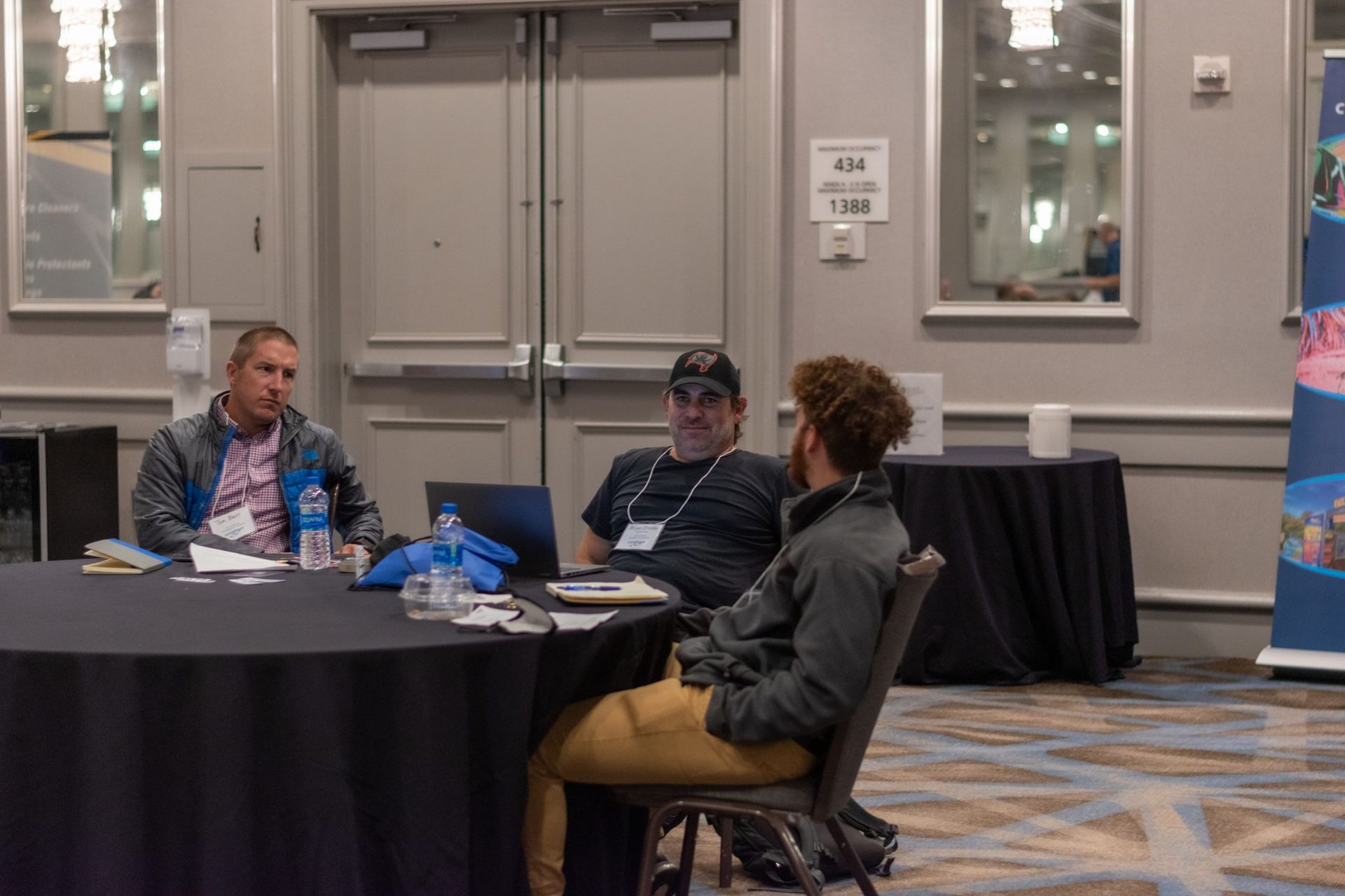A group of people are sitting at a table in a conference room.