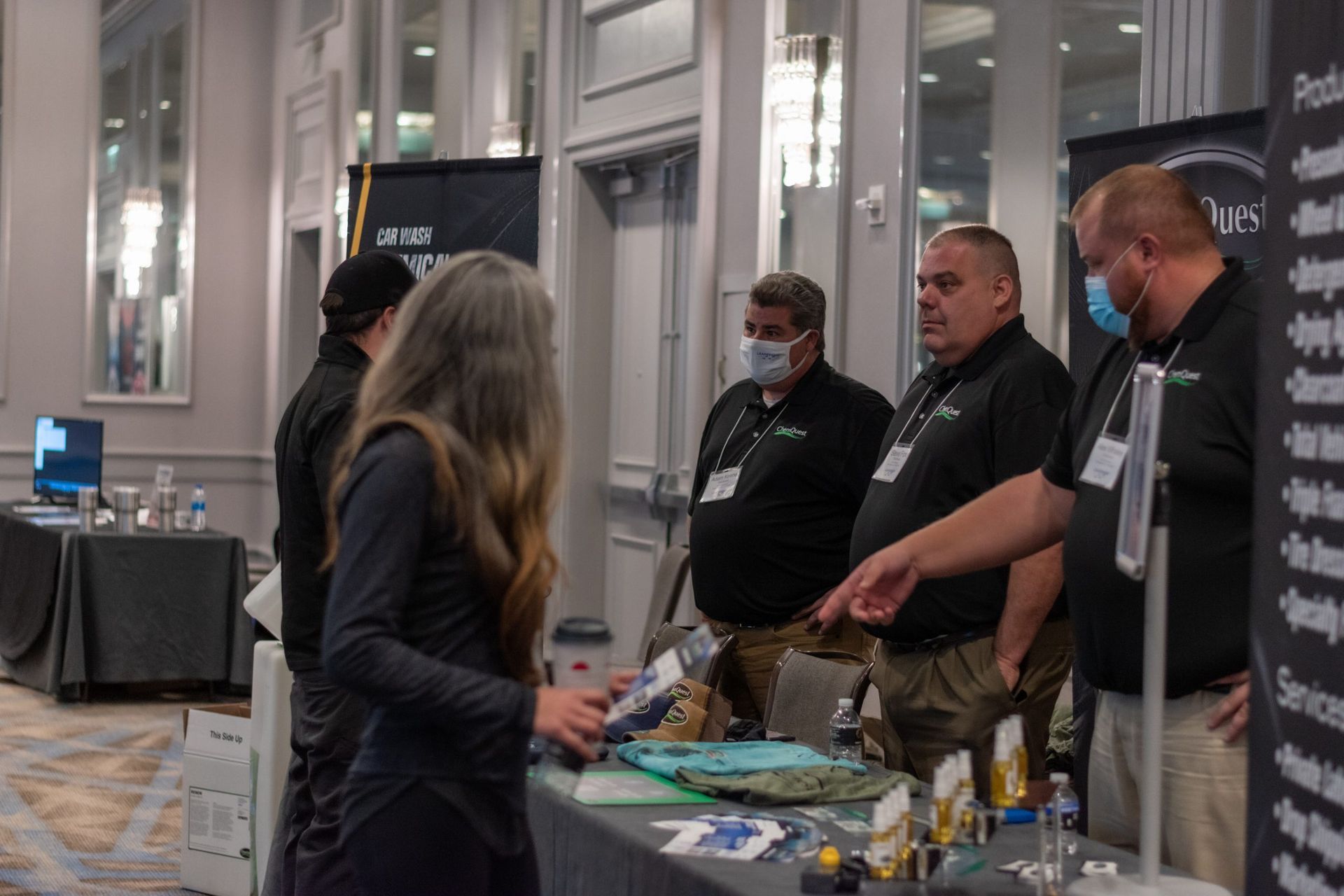A group of people are standing around a table at a convention.